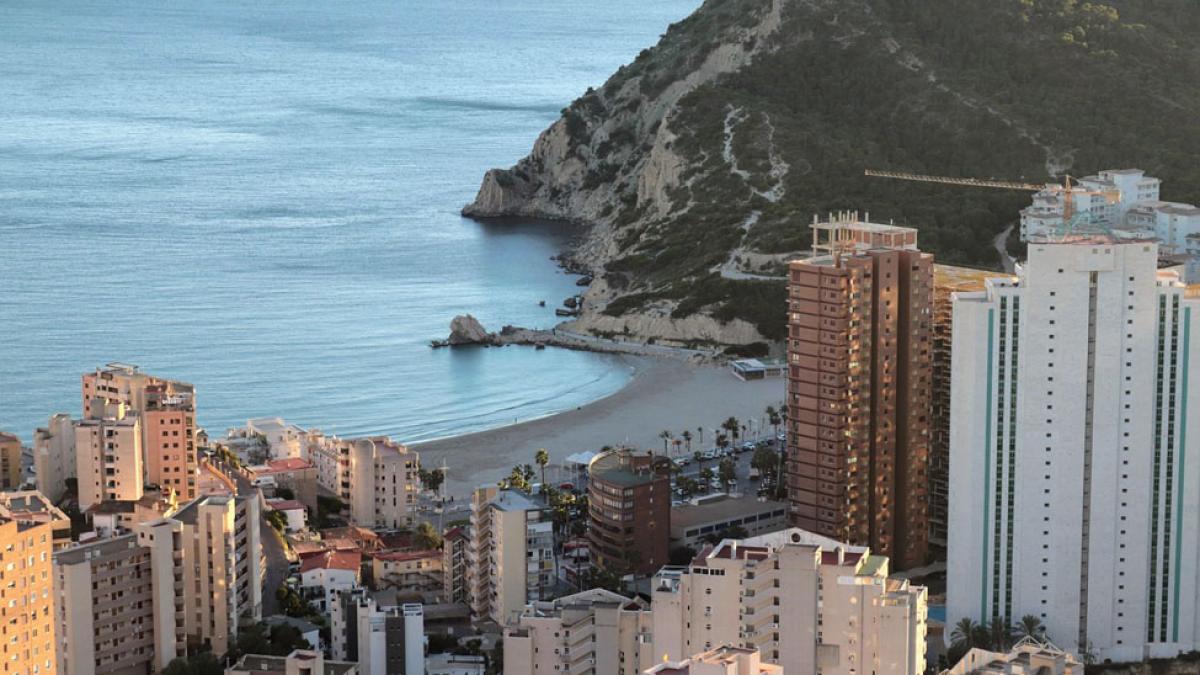 aerial view of a city in coastal Spain with sweeping cliffs, seaside, and modern high-rise buildings