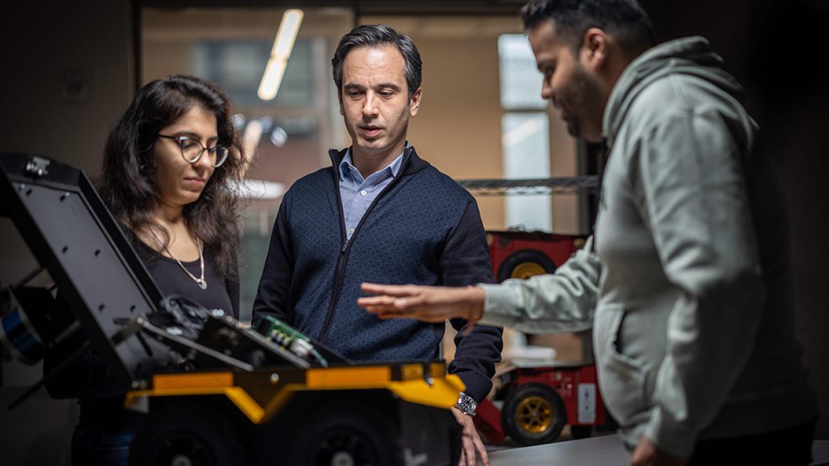 Pace University student demonstrating robotics to a professor.