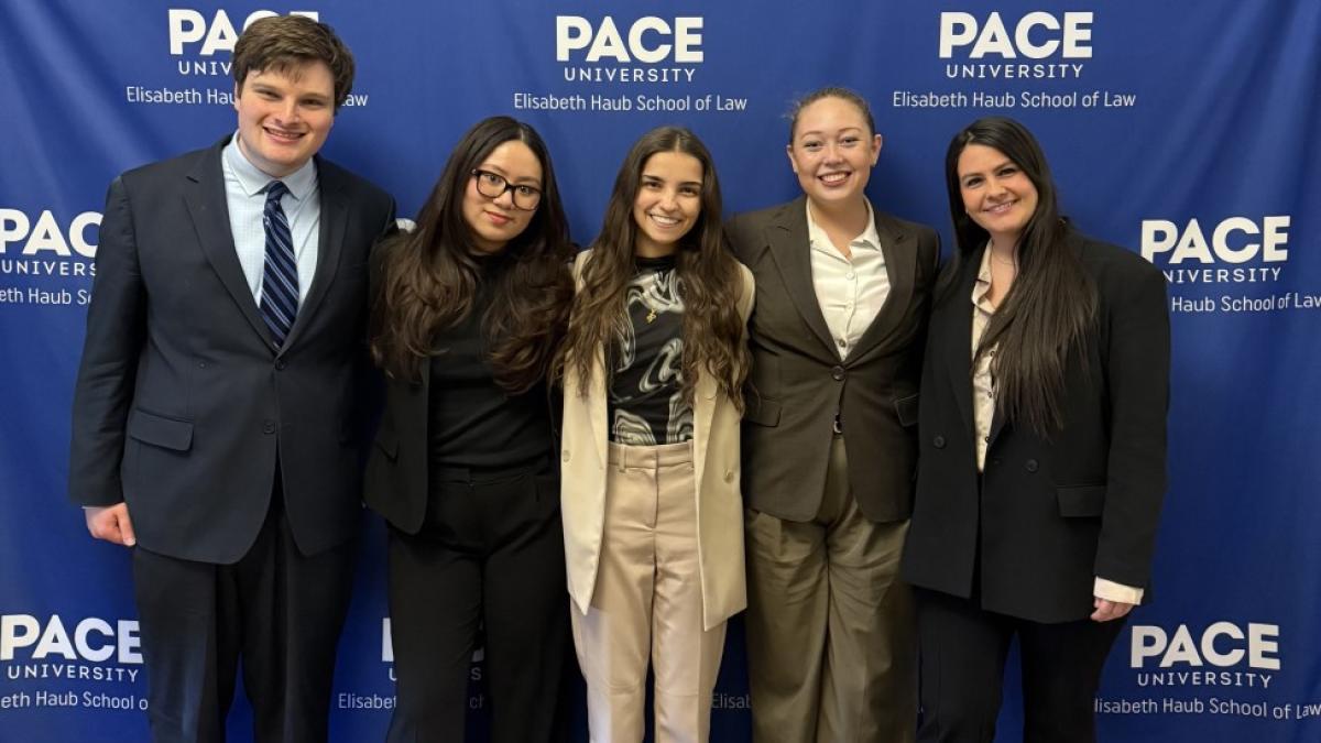 Elisabeth Haub School of Law at Pace University's ICC Moot team standing in front of Pace banner