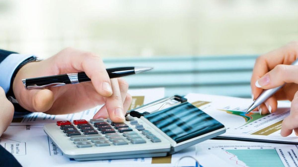 two people doing calculations with calculators and pens