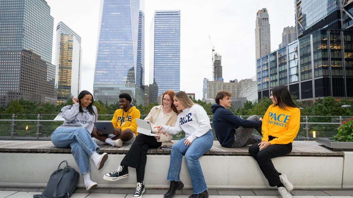 Pace students chatting with one another in Lower Manhattan with skyscrapers in the background