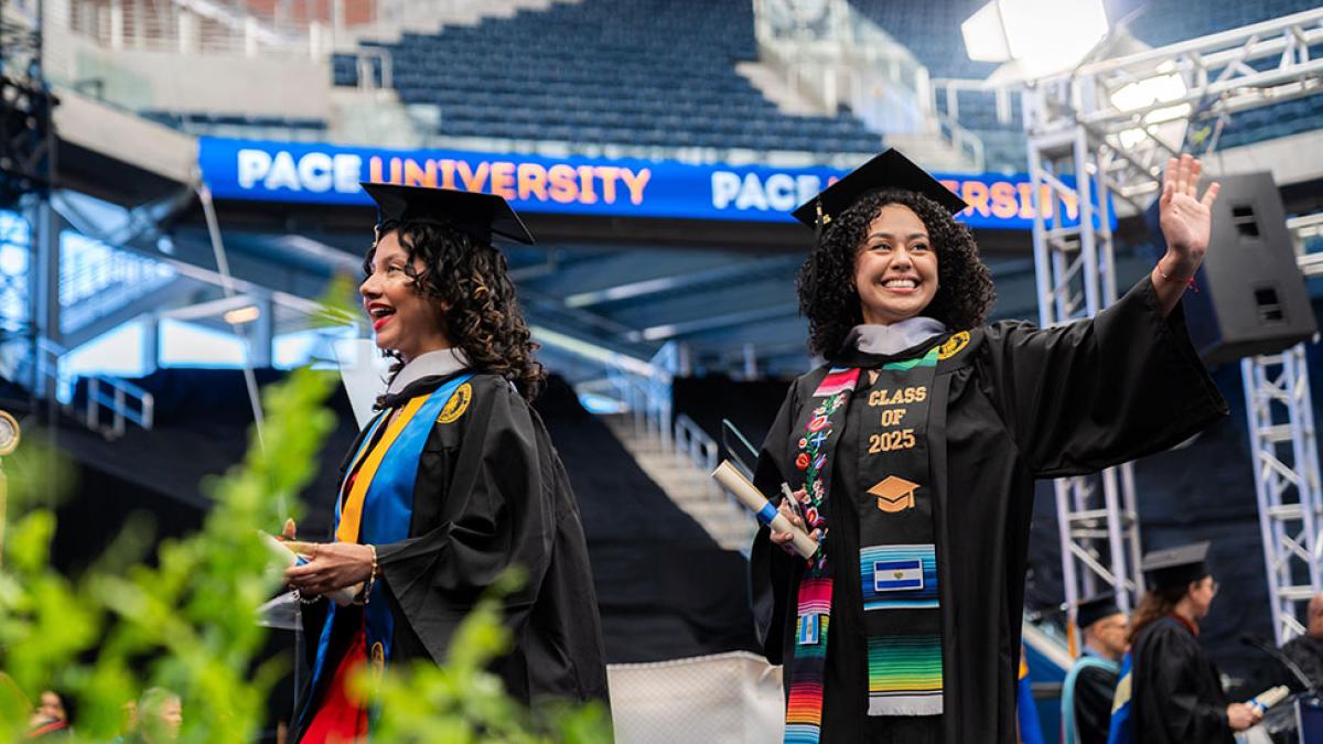 Pace University 2025 graduates walking across the commencement stage.