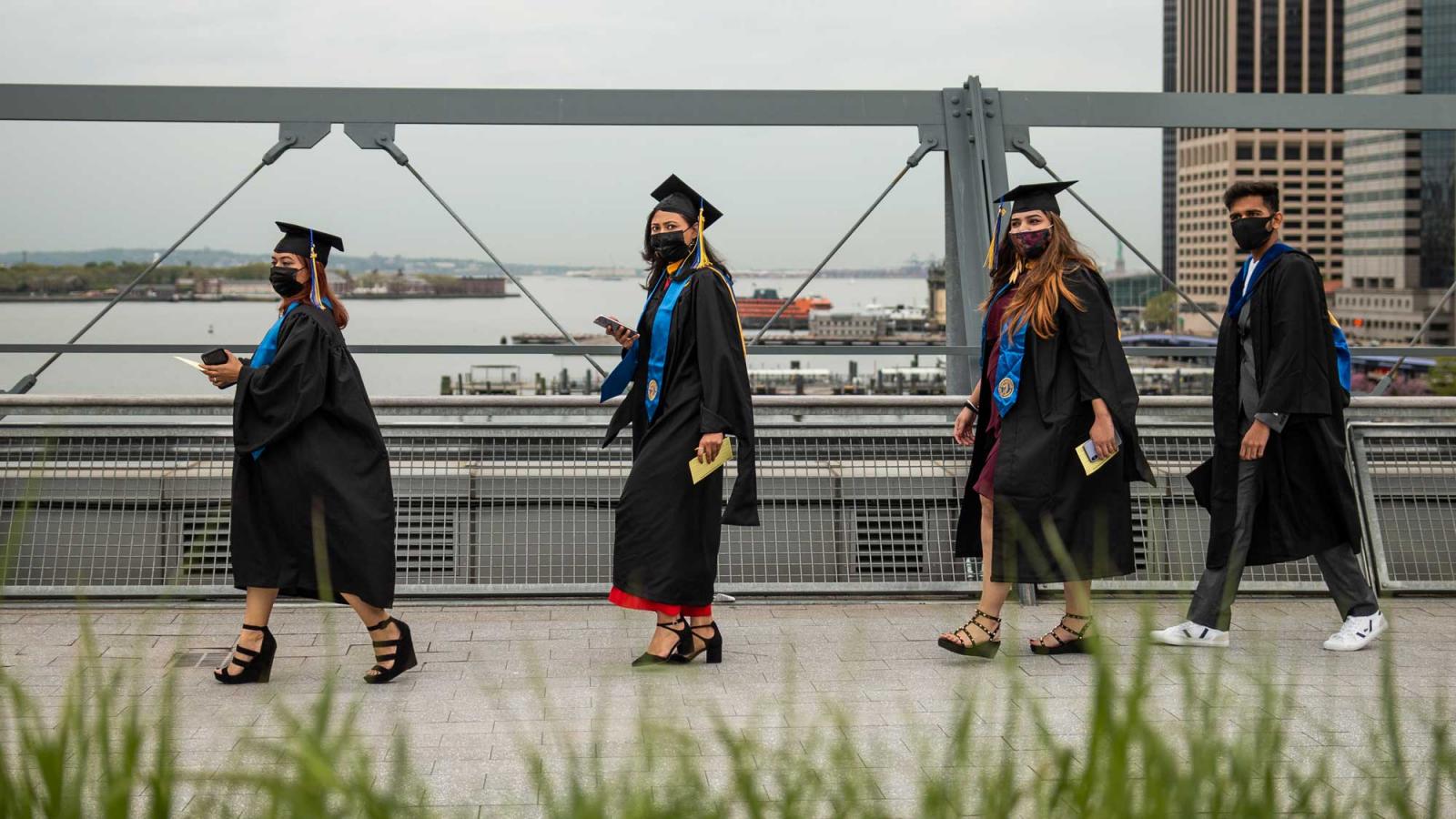 students in academic regalia and masks