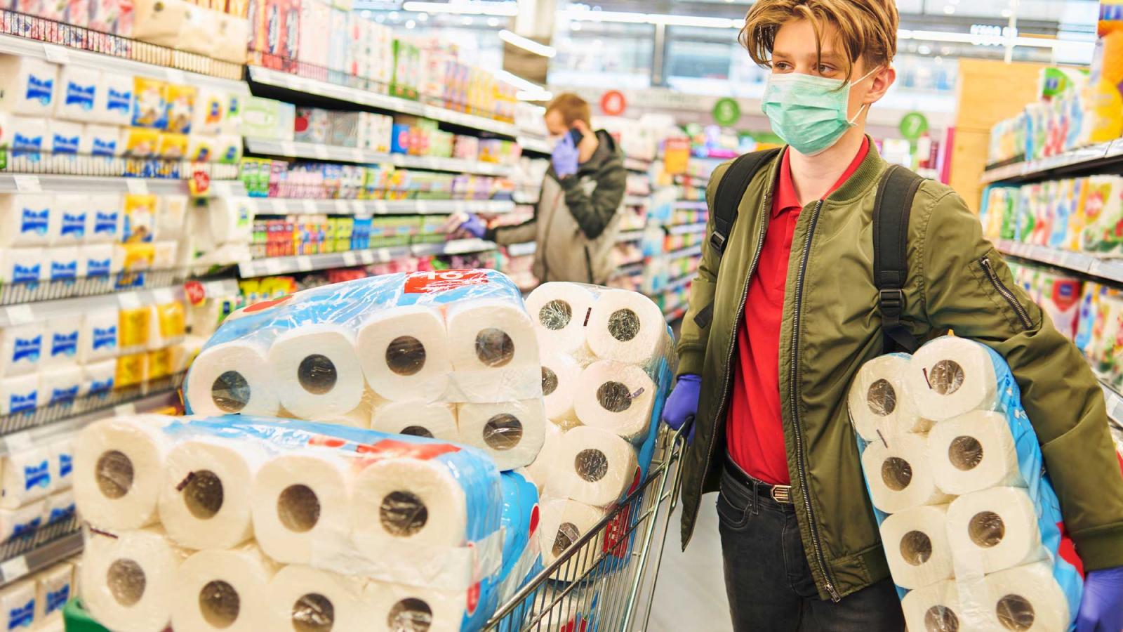 man with a shopping cart full of toilet paper