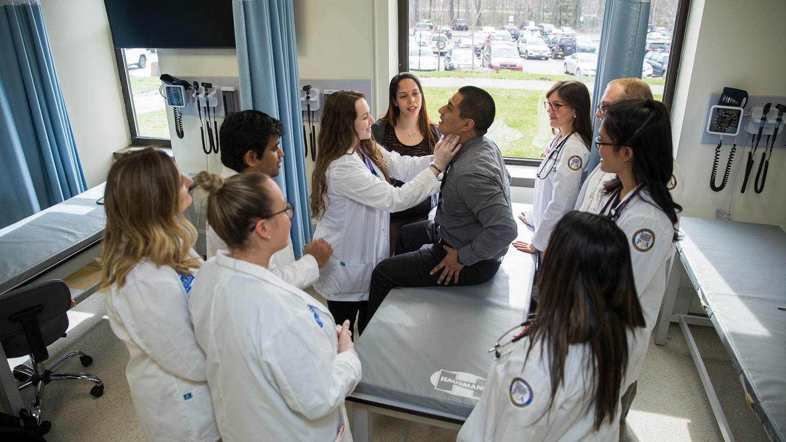 Group of students working on a patient in a classroom setting.