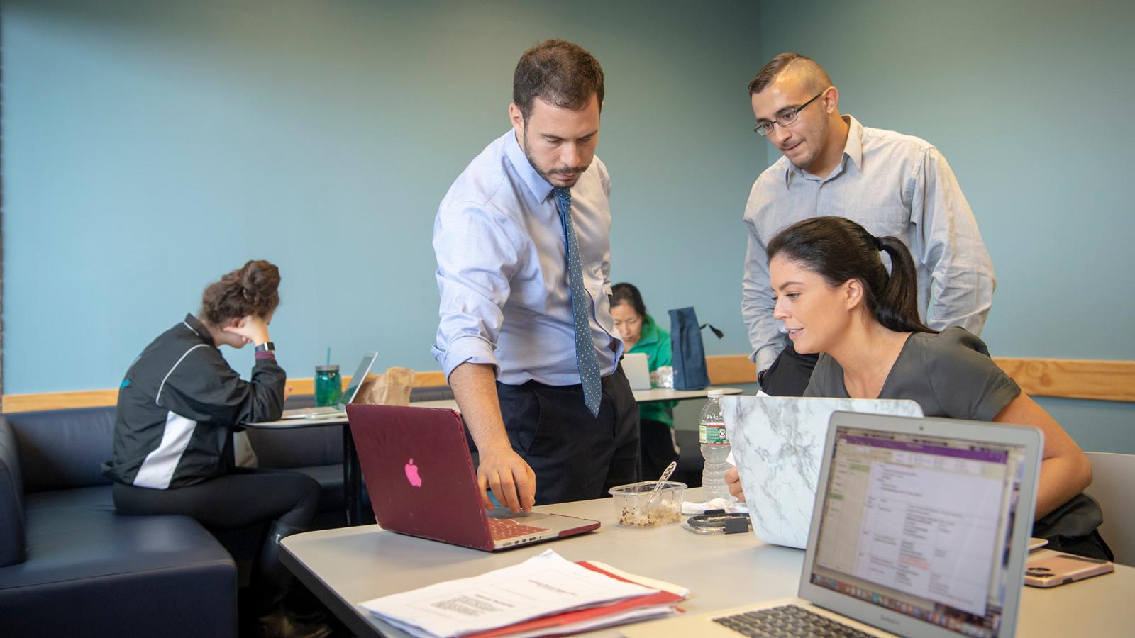 CHP students standing in front of a computer working together.