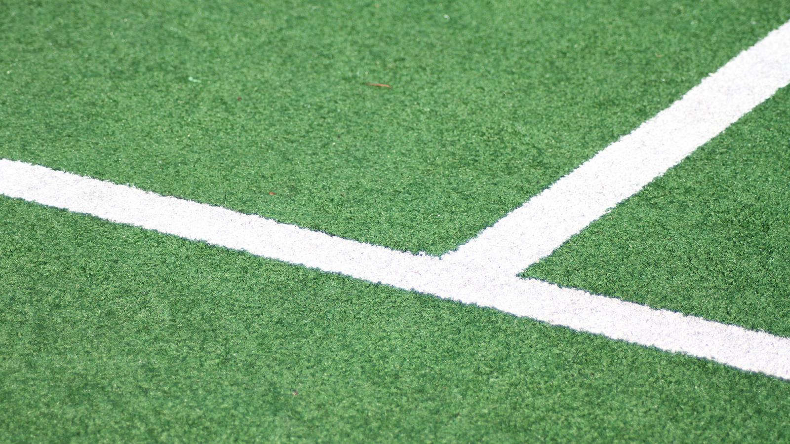 close view of field hockey pitch with chalk lines