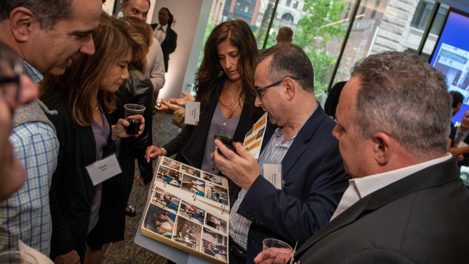 group of people looking at a photo album