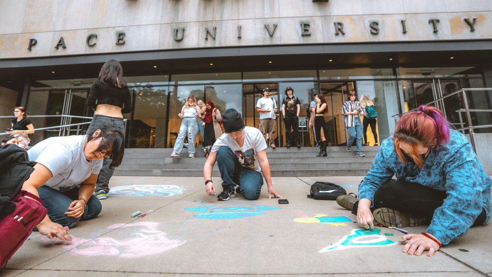 people drawing in chalk outside one pace plaza