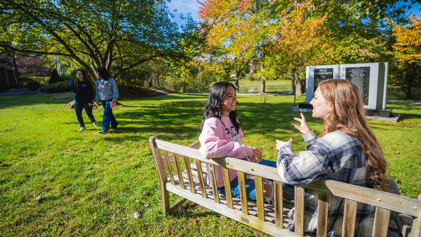 Two students conversing on a bench on Westchester Campus