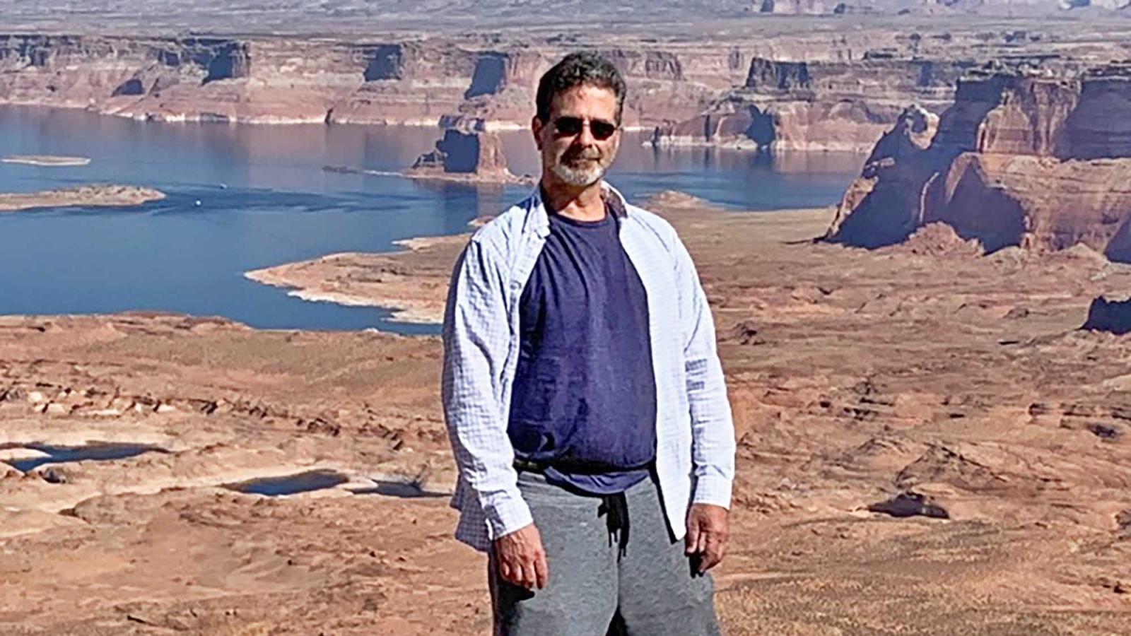 Professor David Cassuto outside, in front of a river and a dry, open landscape