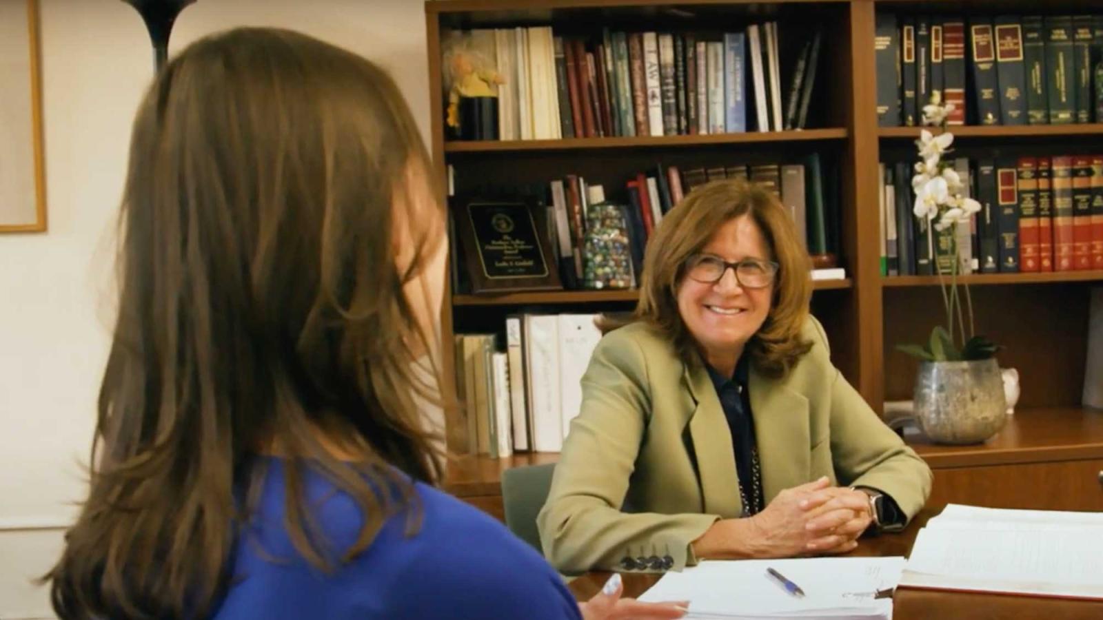 A faculty member speaking to a student on the Elisabeth Haub School of Law campus