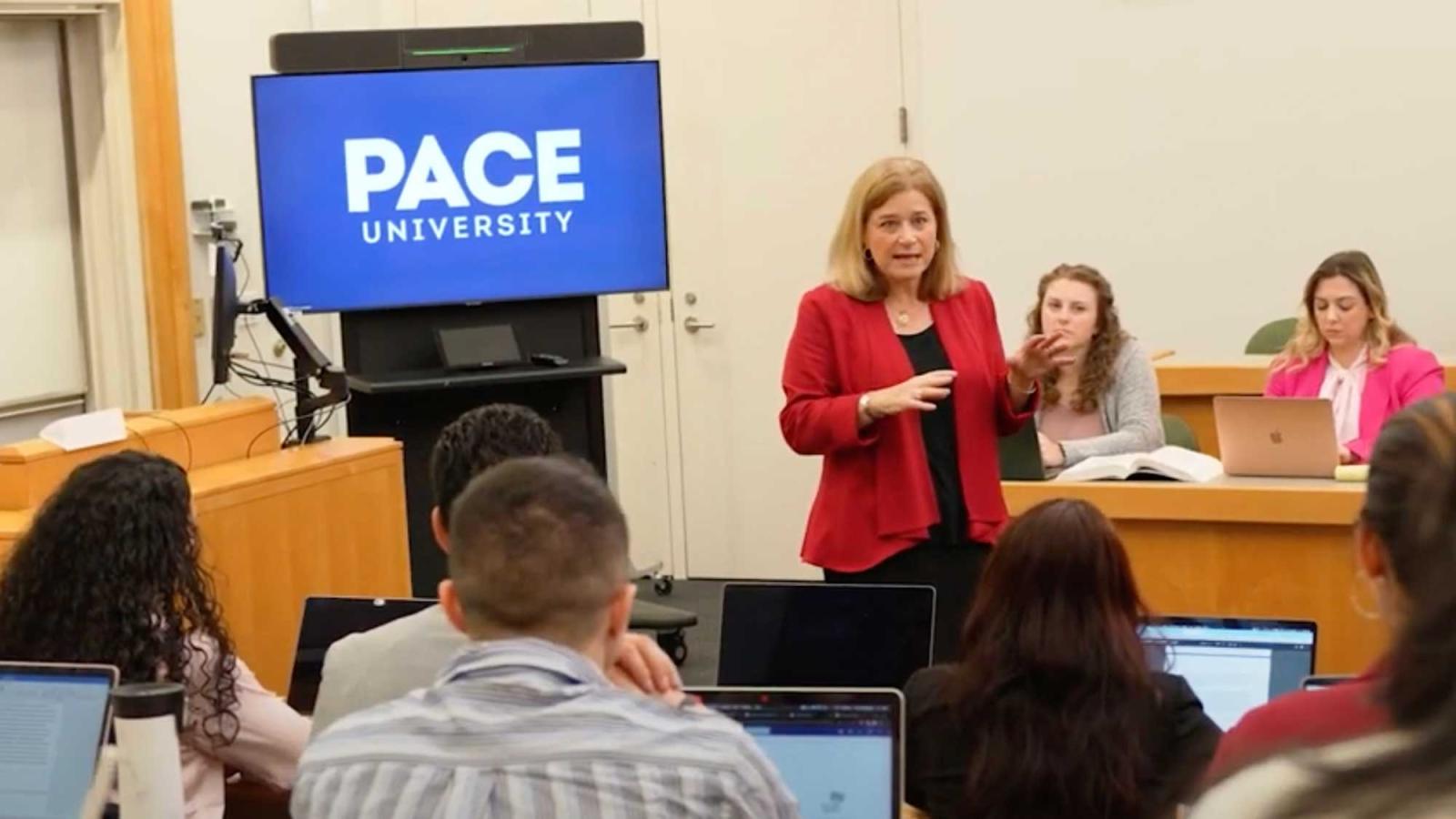 A professor speaking to a group of students on the Elisabeth Haub School of Law campus