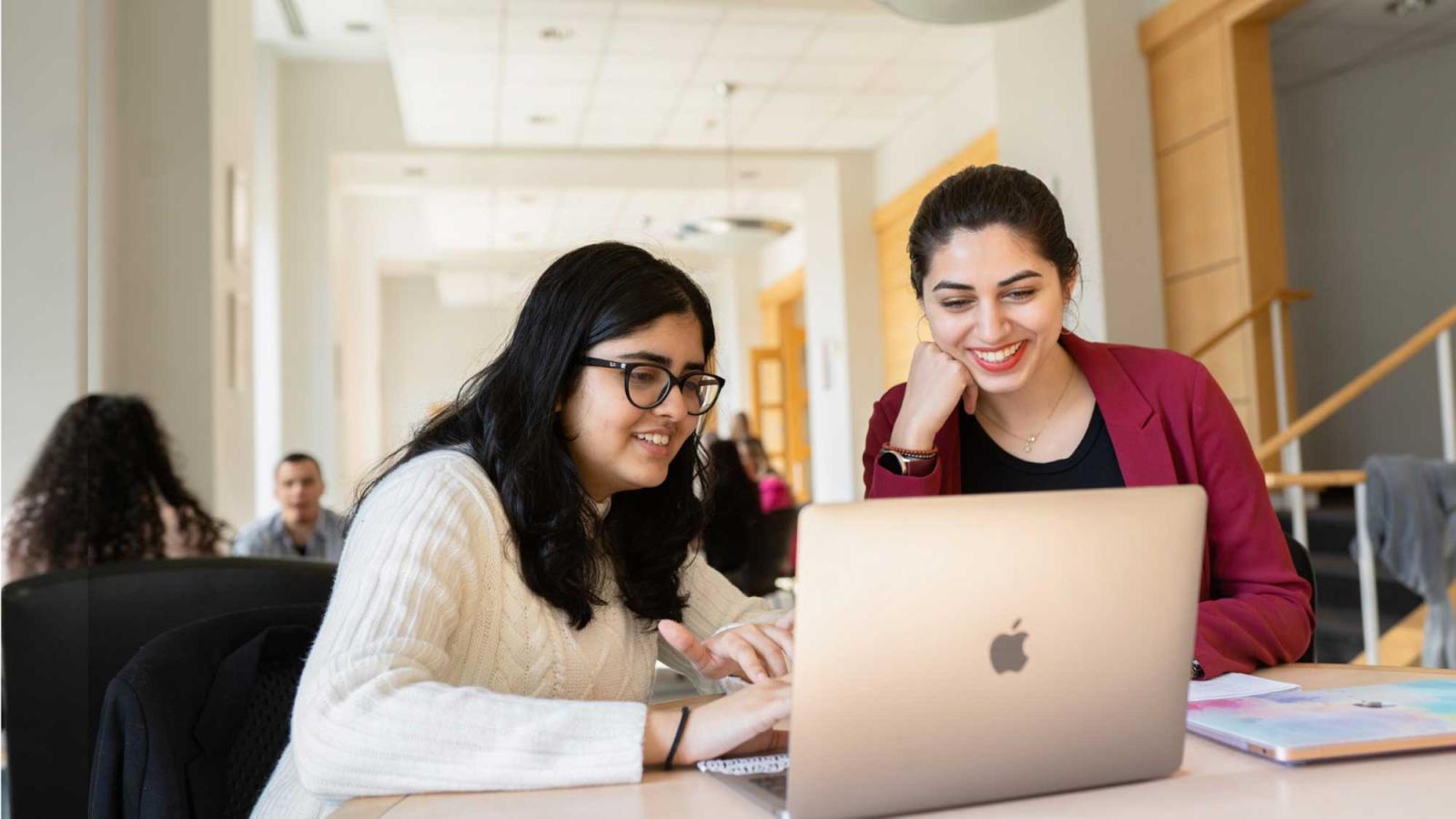 Two students looking at a laptop computer screen