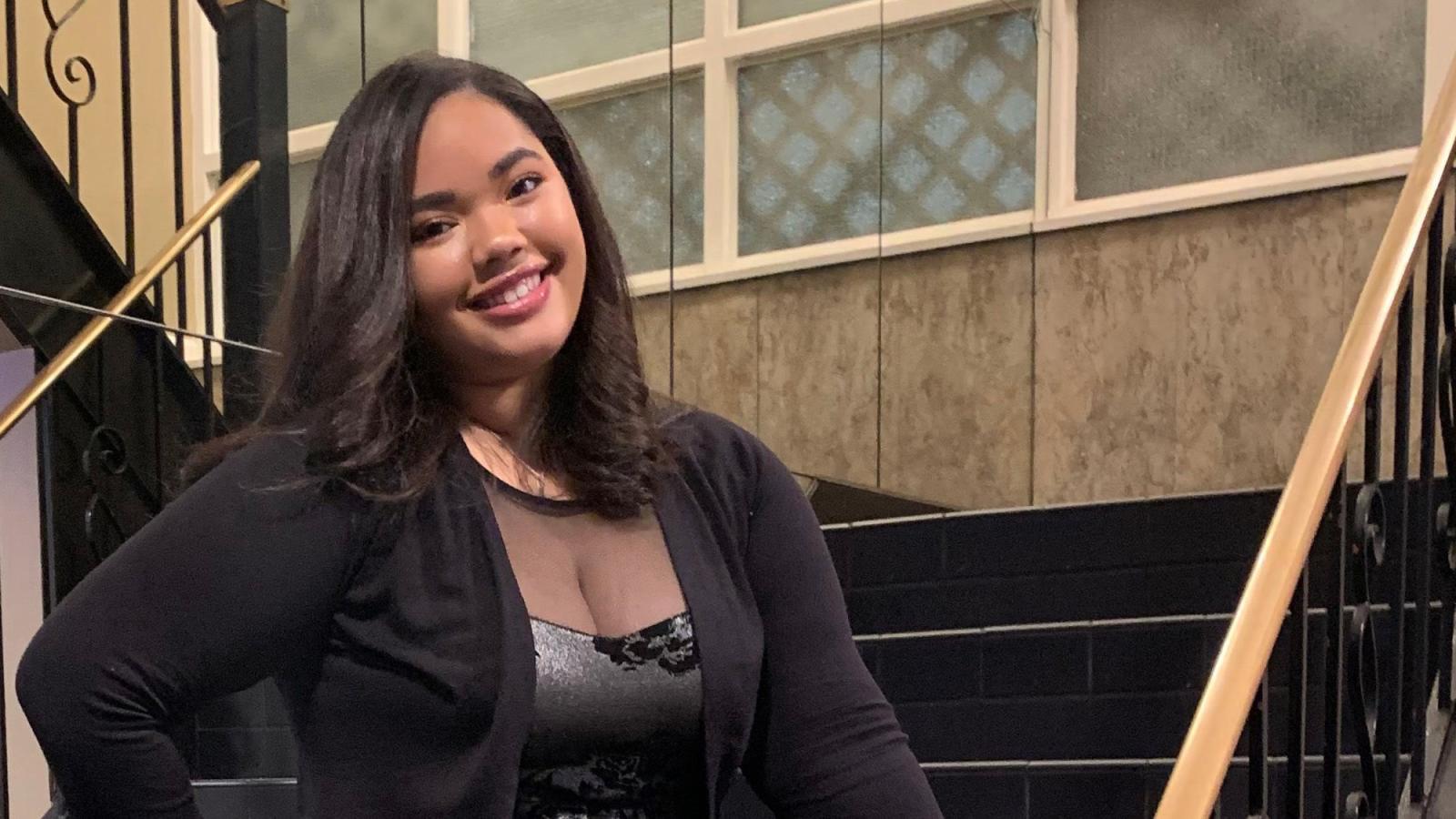 Pace student Valentina Rojas Abreu stands in front of a staircase  