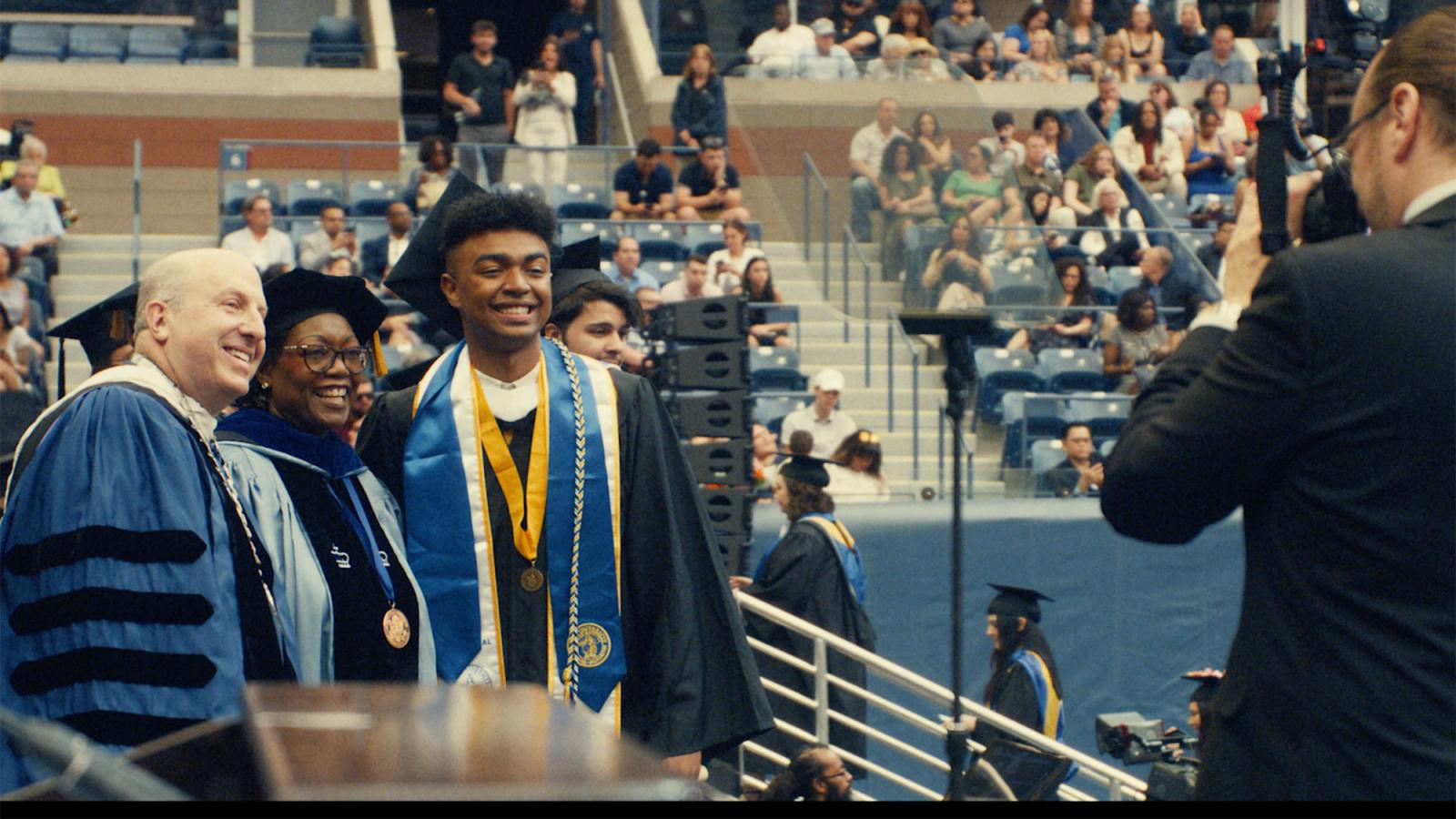 Pace University's Political Science graduate Jeremiah Williams with Pace President Marvin Krislov and  Tresmaine R. Grimes, PhD, Dean of the Dyson College of Arts and Science and School of Education huddled together as a photographer takes their photo