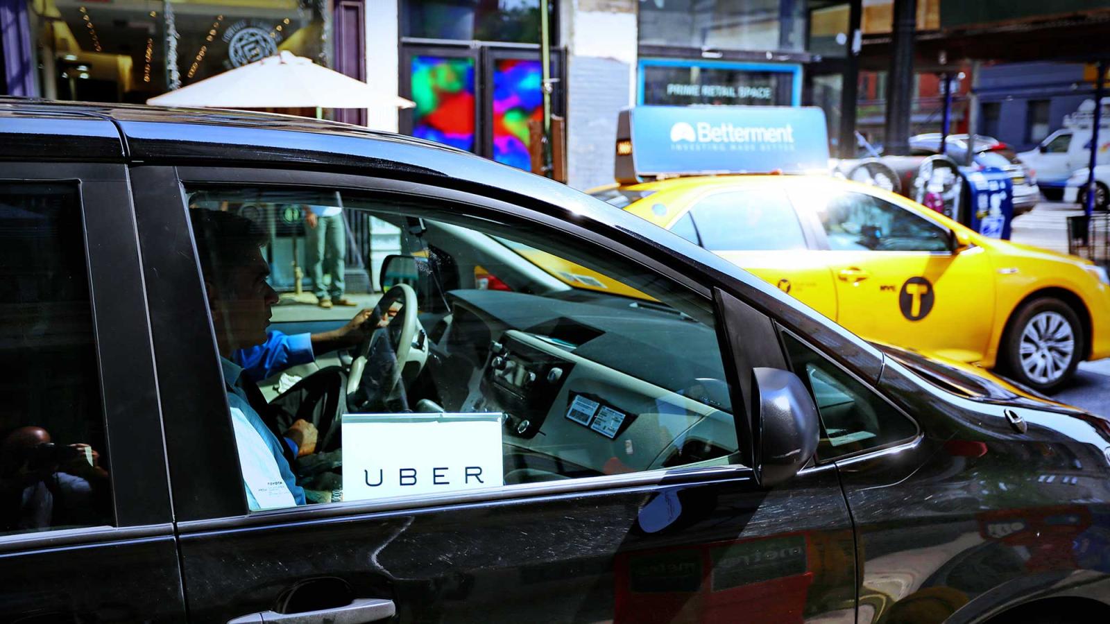 An Uber and a Taxi on a New York City street