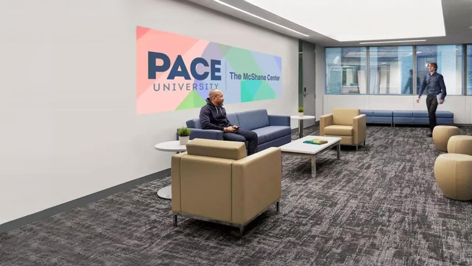 Pace University's McShane Center lobby with a person sitting in a chair being greeted by another