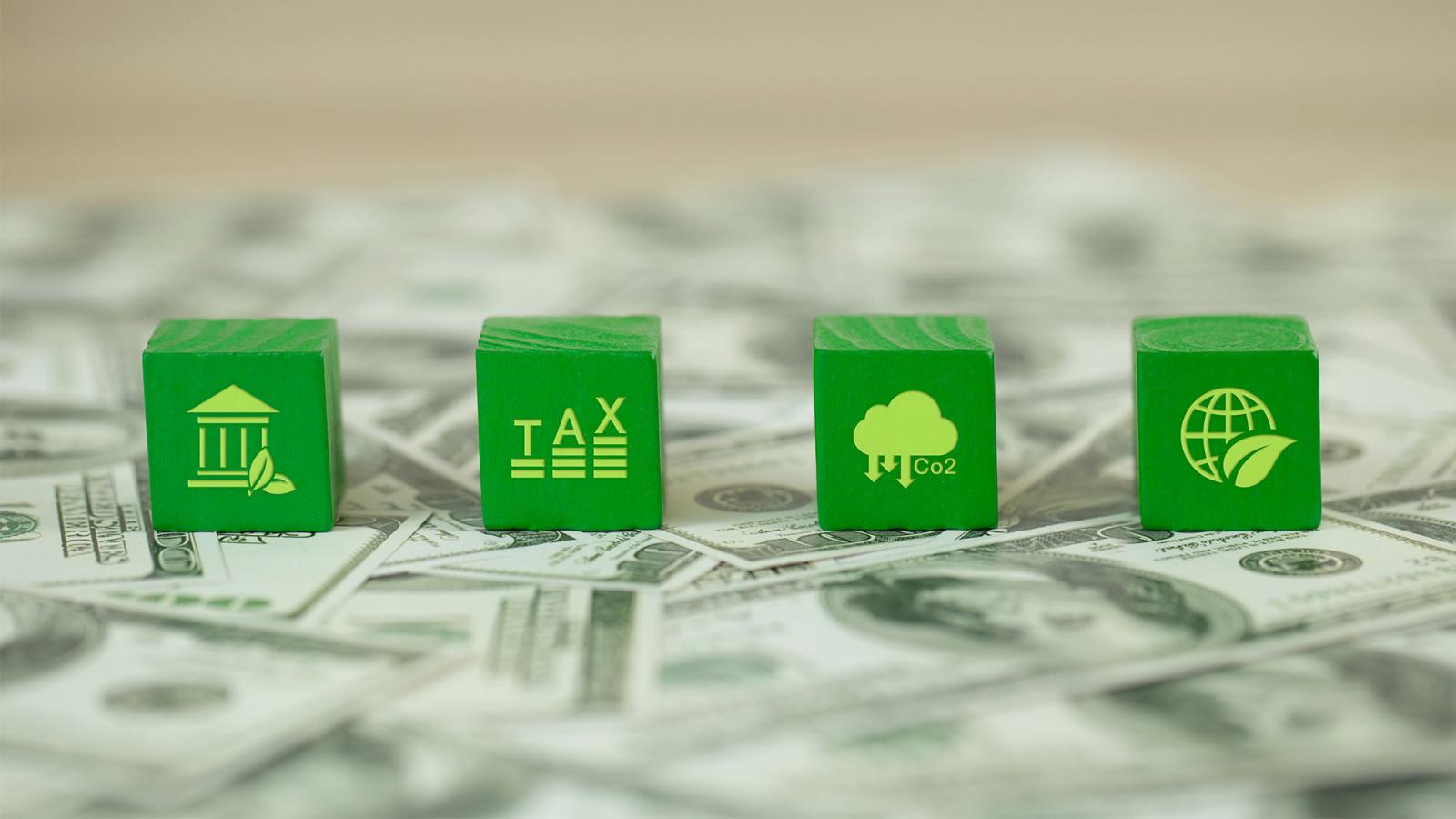 Four green cubes with tax symbols printed on each one.