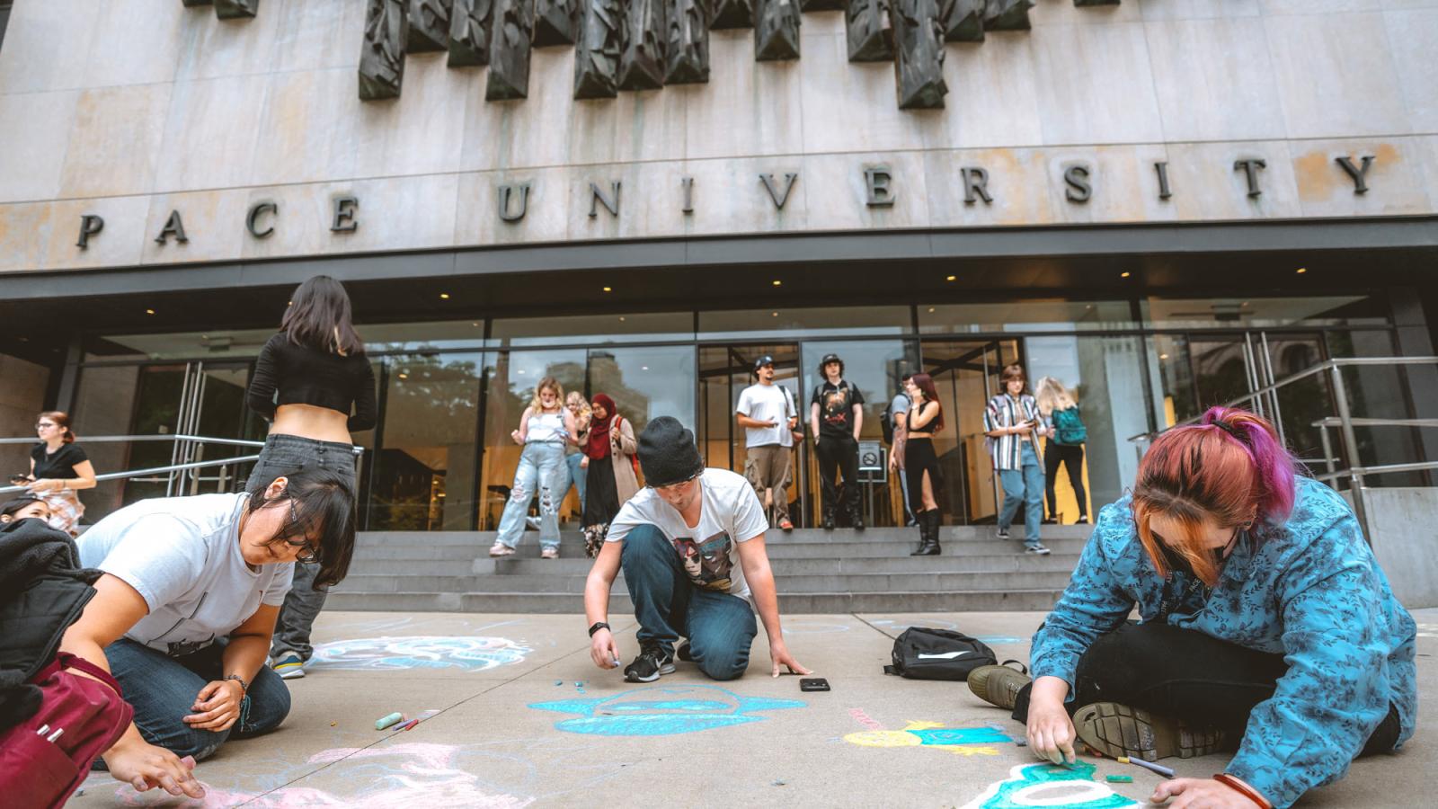 Pace University students using sidewalk chalk outside of One Pace Plaza