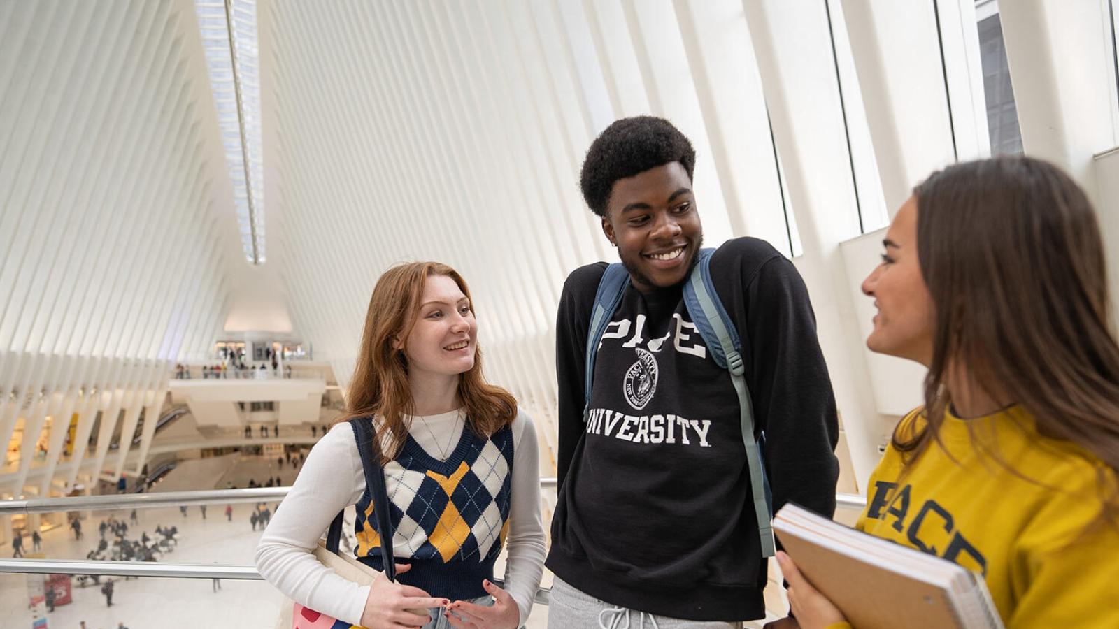 Three Pace University students talking in the Oculus train station in downtown Manhattan