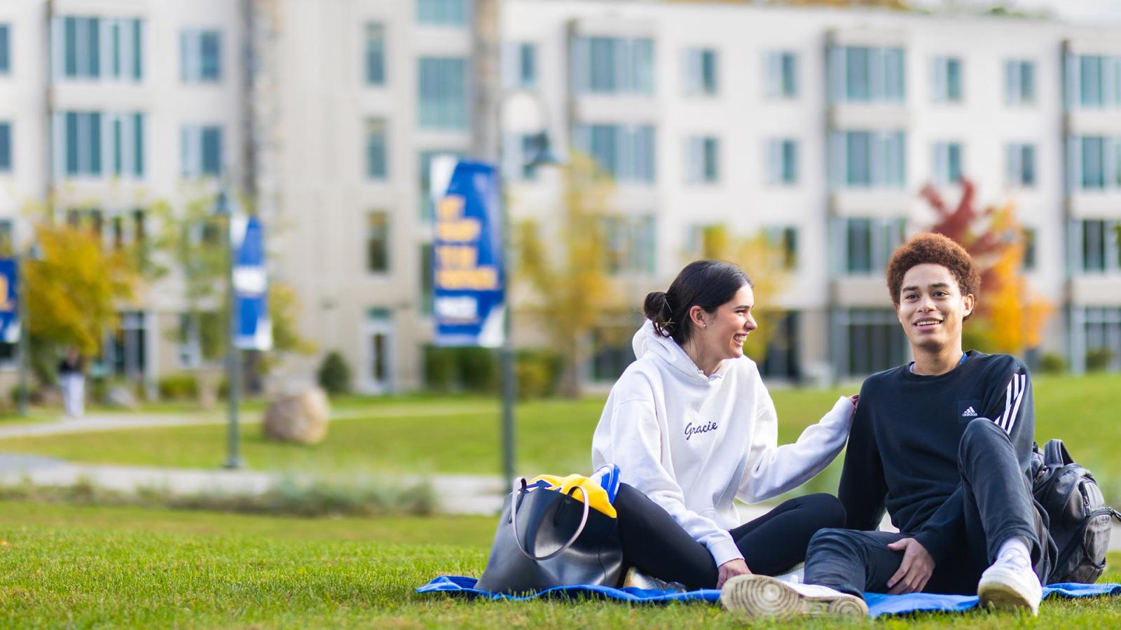Pace students sitting on the lawn of the Pleasantville Campus. 