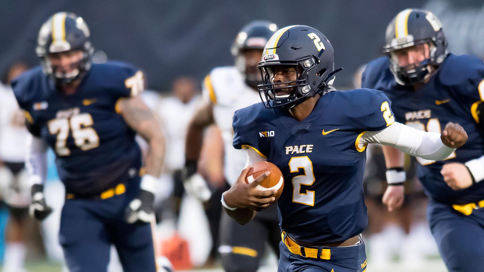 Pace University football players running on the field.