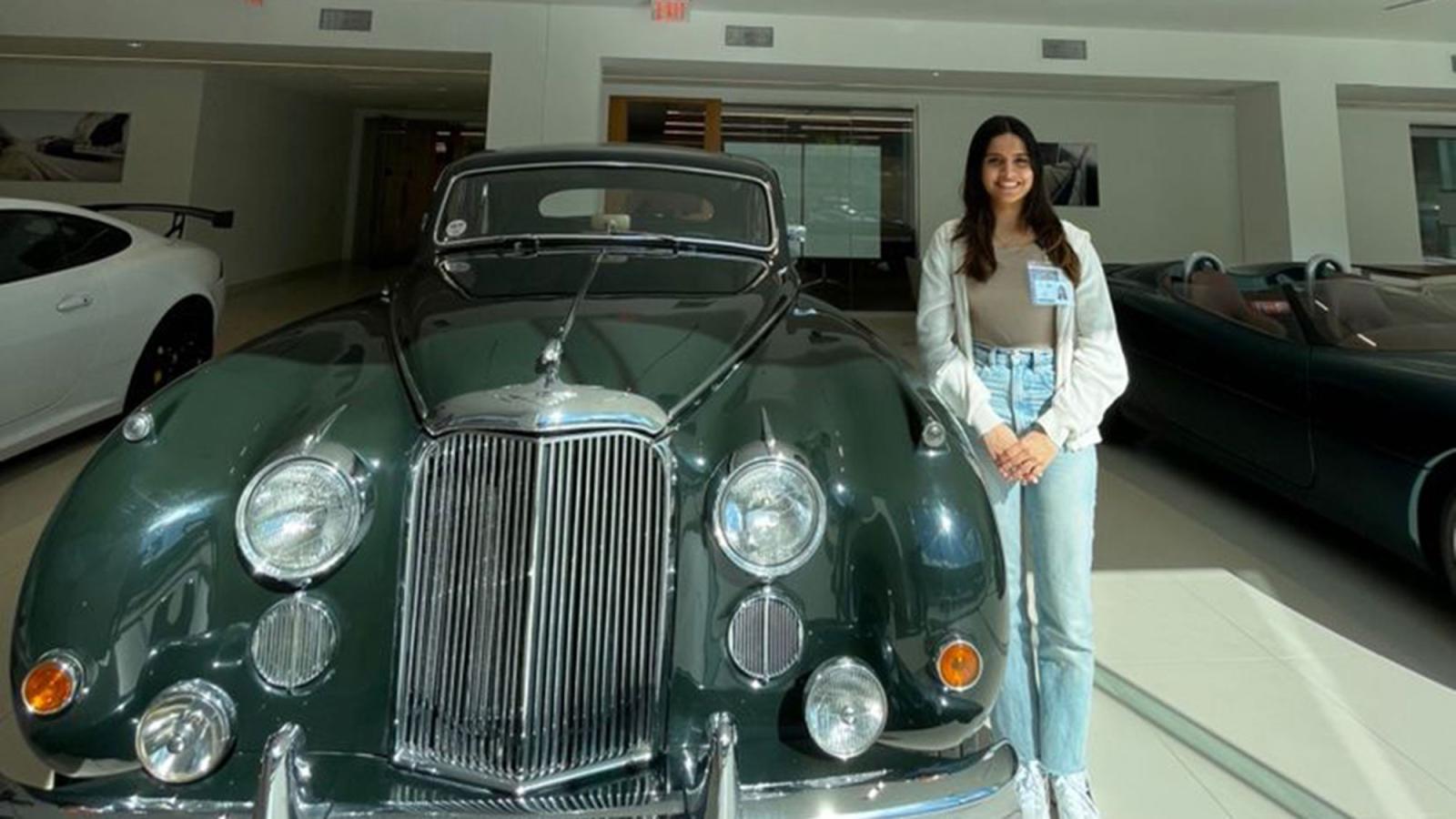 Lubin graduate student Cianna Bar '25 standing next to a vintage car.