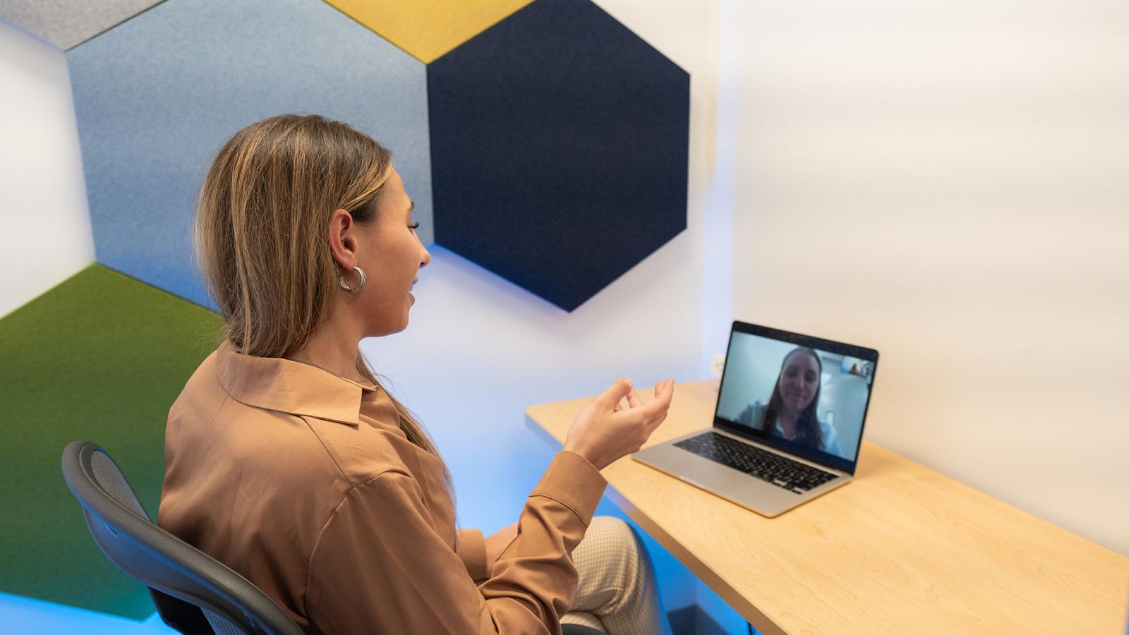 Pace University student sitting in a communications lab conducting a Zoom session.