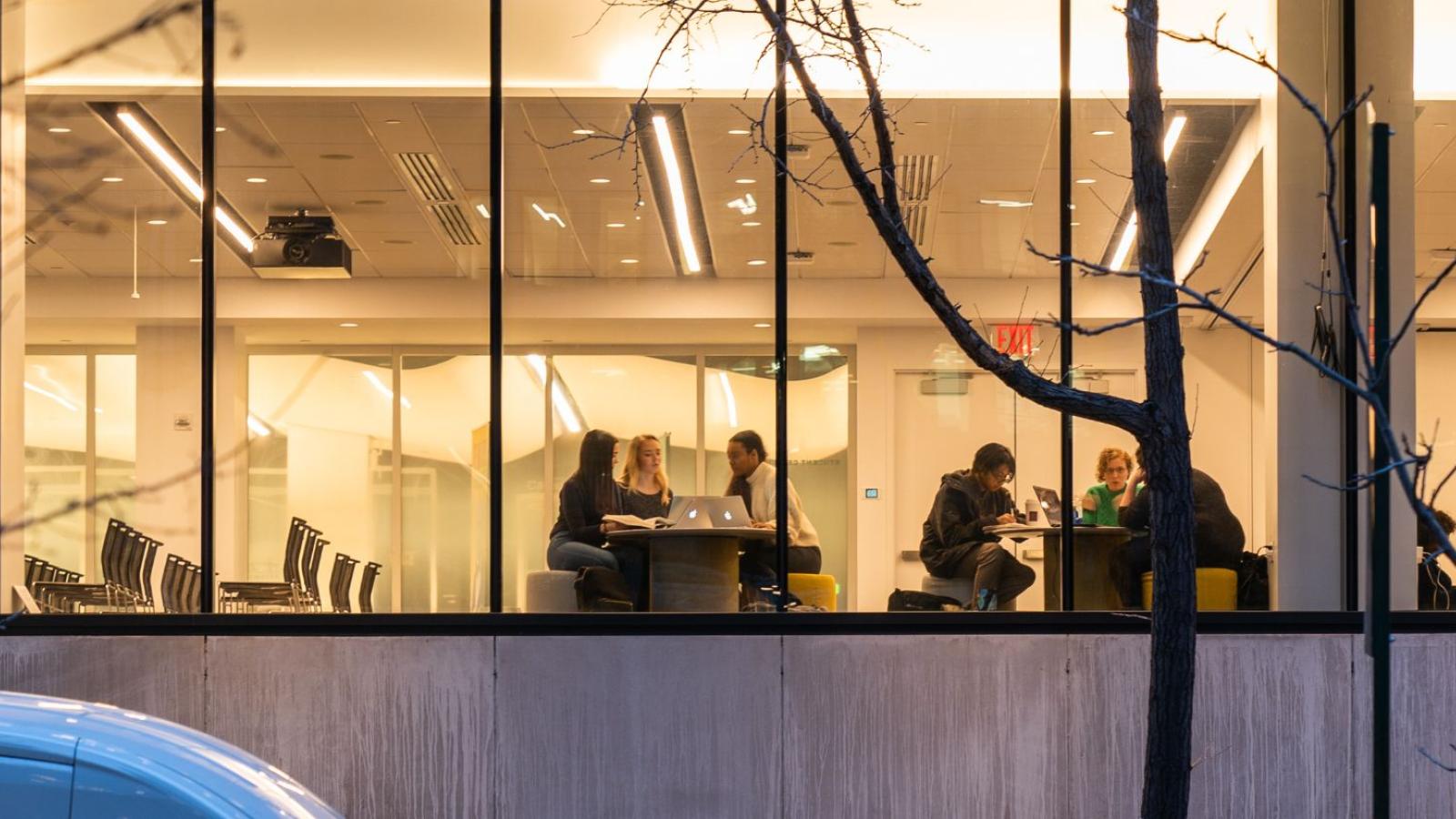 Pace University view of students studying at a table from the exterior
