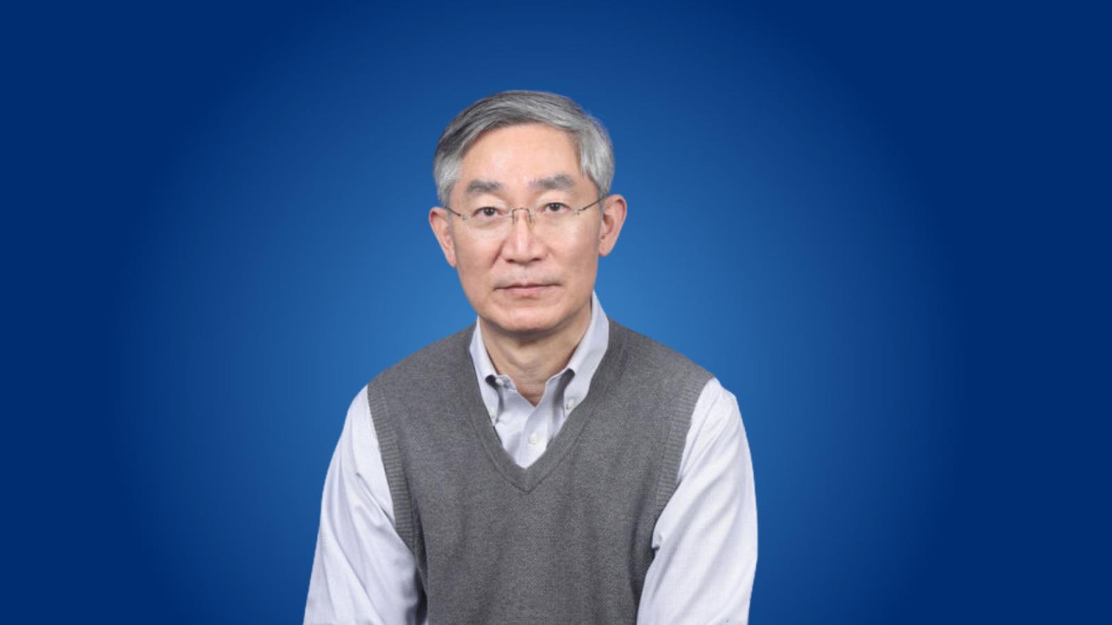 Pace University Seidenberg professor, Dr. Namchul Shin posing for a photo in front of a blue background.