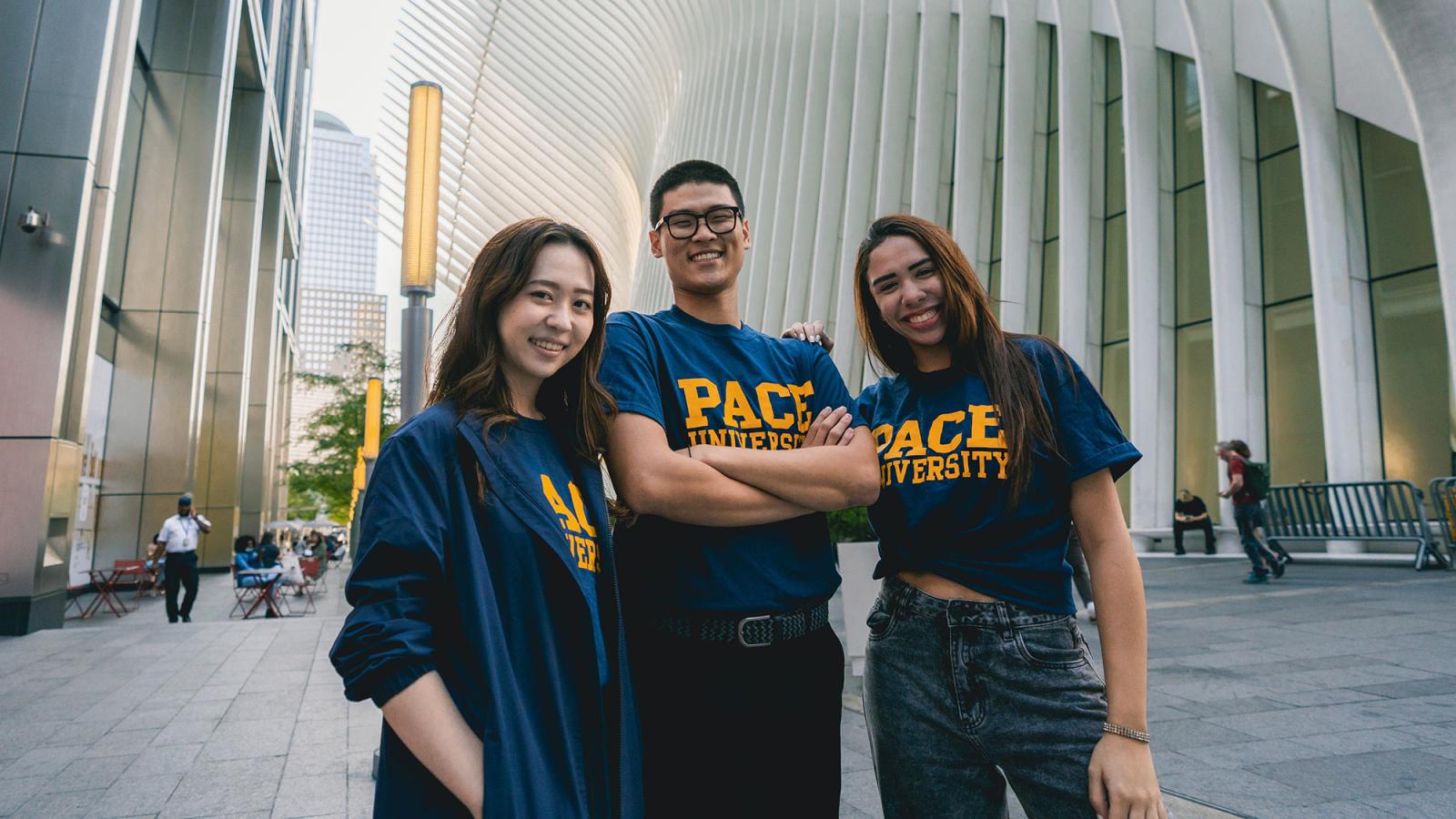 Three Pace University students posing for the camera at the World Trade Center station in Manhattan