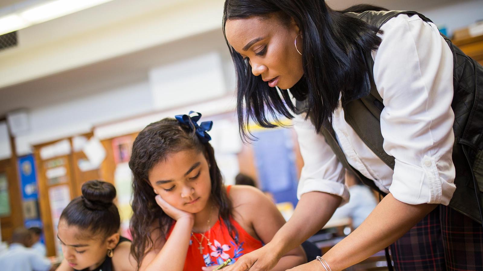 A primary school teacher instructing a student