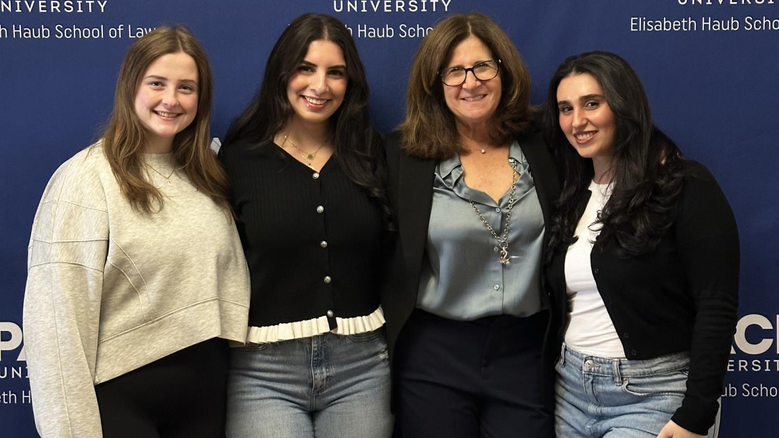 Elisabeth Haub School of Law at Pace University Professor Leslie Tenzer and students pictured in front of Pace banner