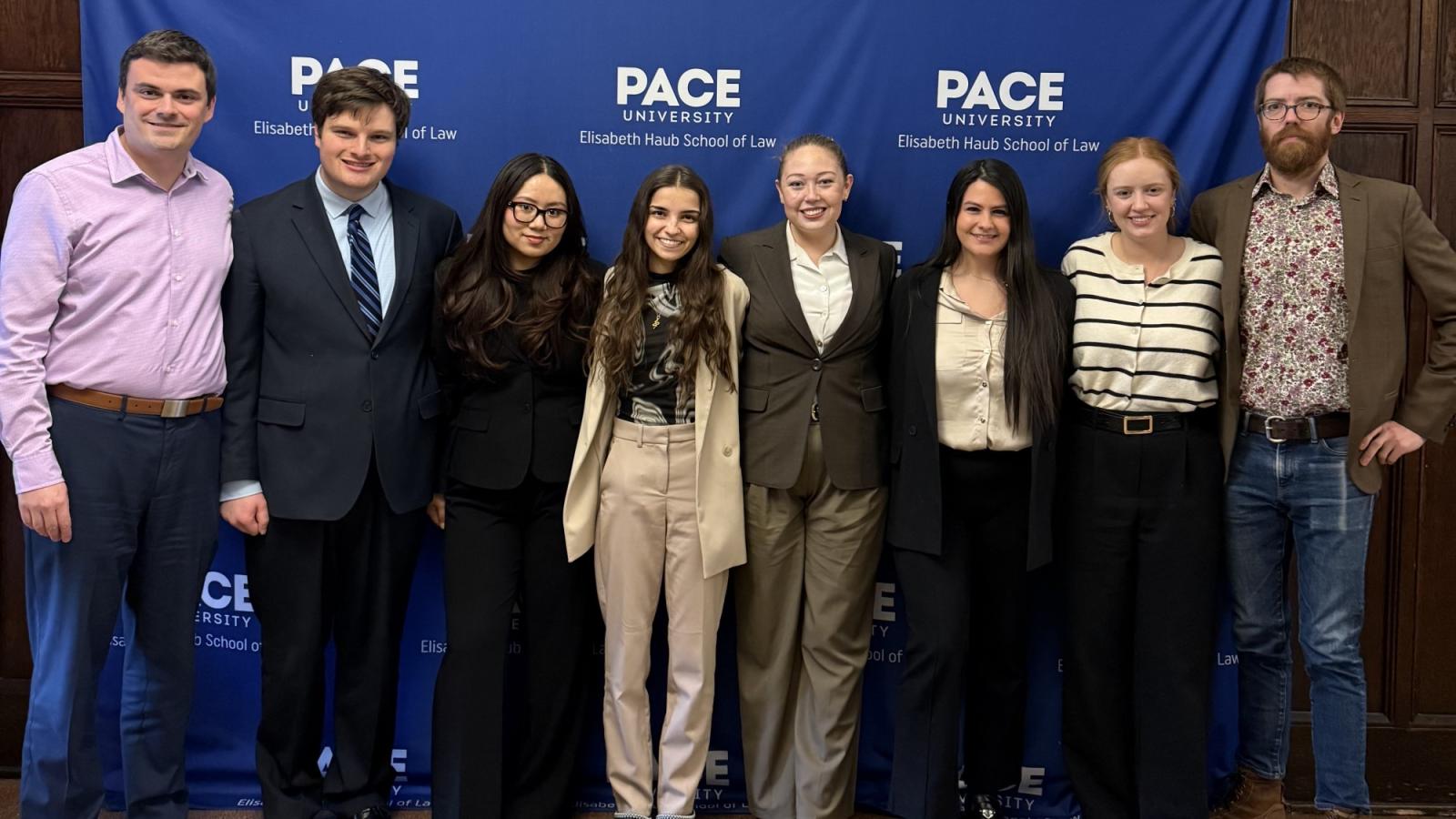 Elisabeth Haub School of Law at Pace University's ICC Moot team and coaches standing in front of Pace banner