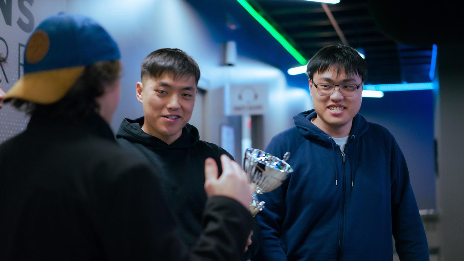 Pace Esports students smile and hold a trophy