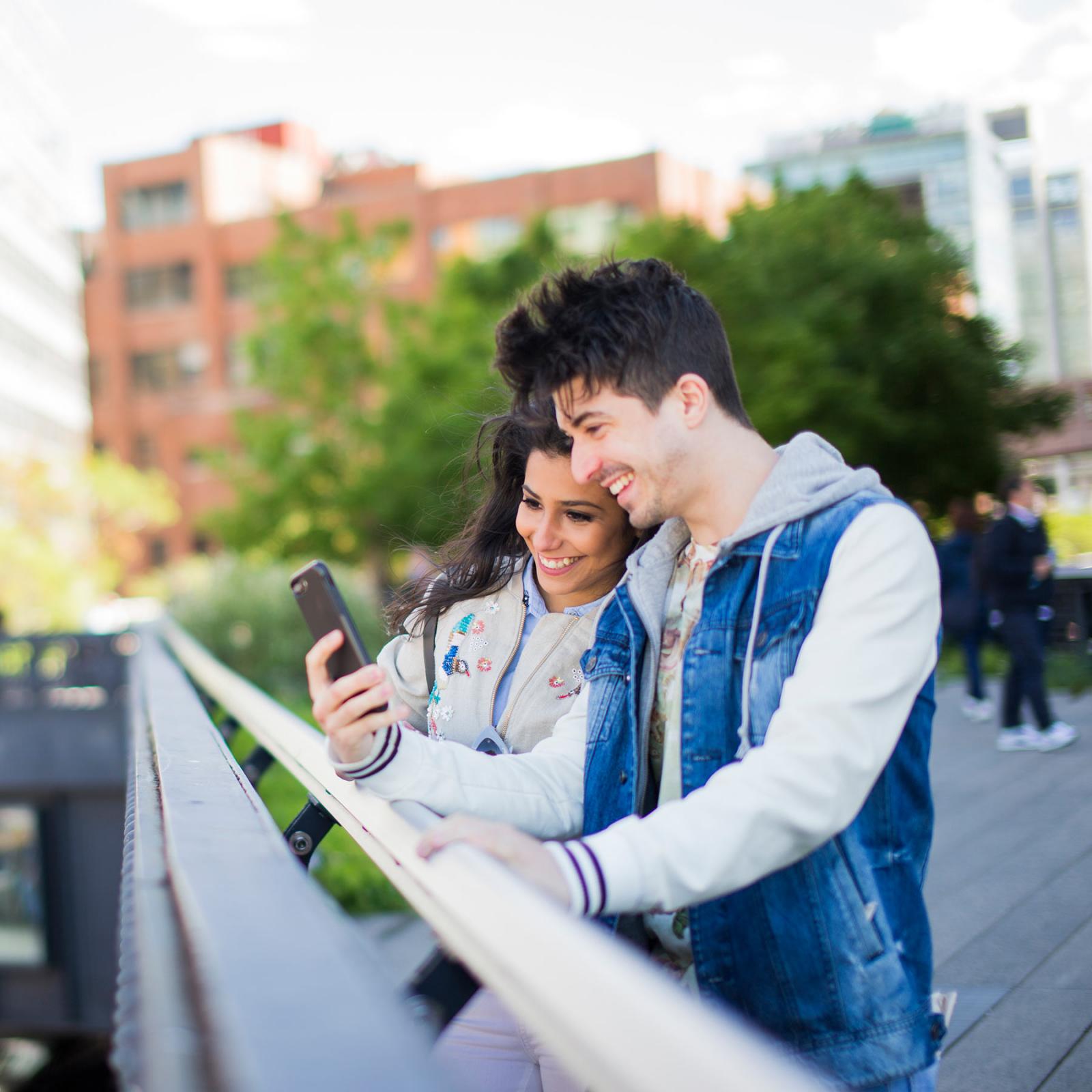 Students looking at their phone and smiling.