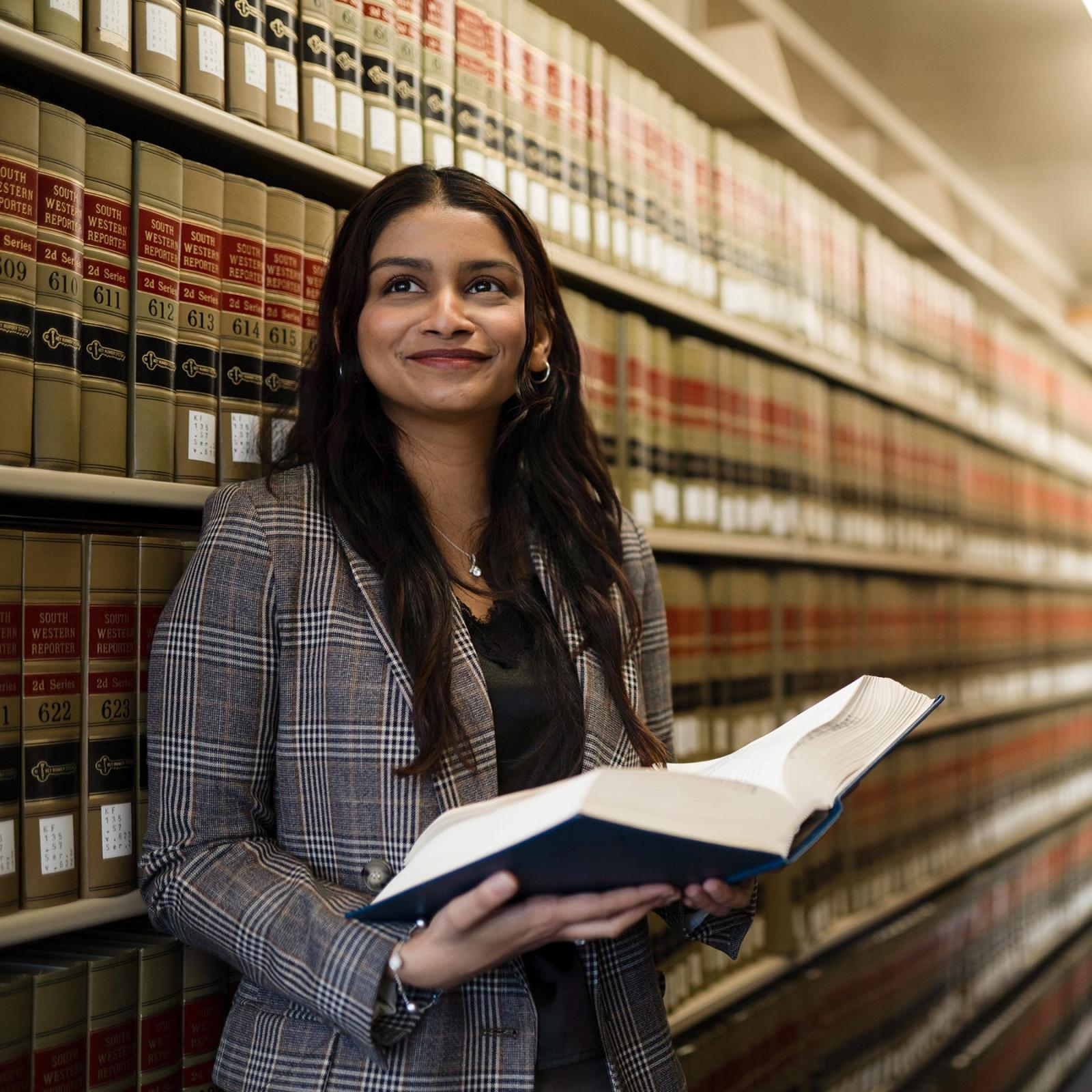 Law student in libary holding a book