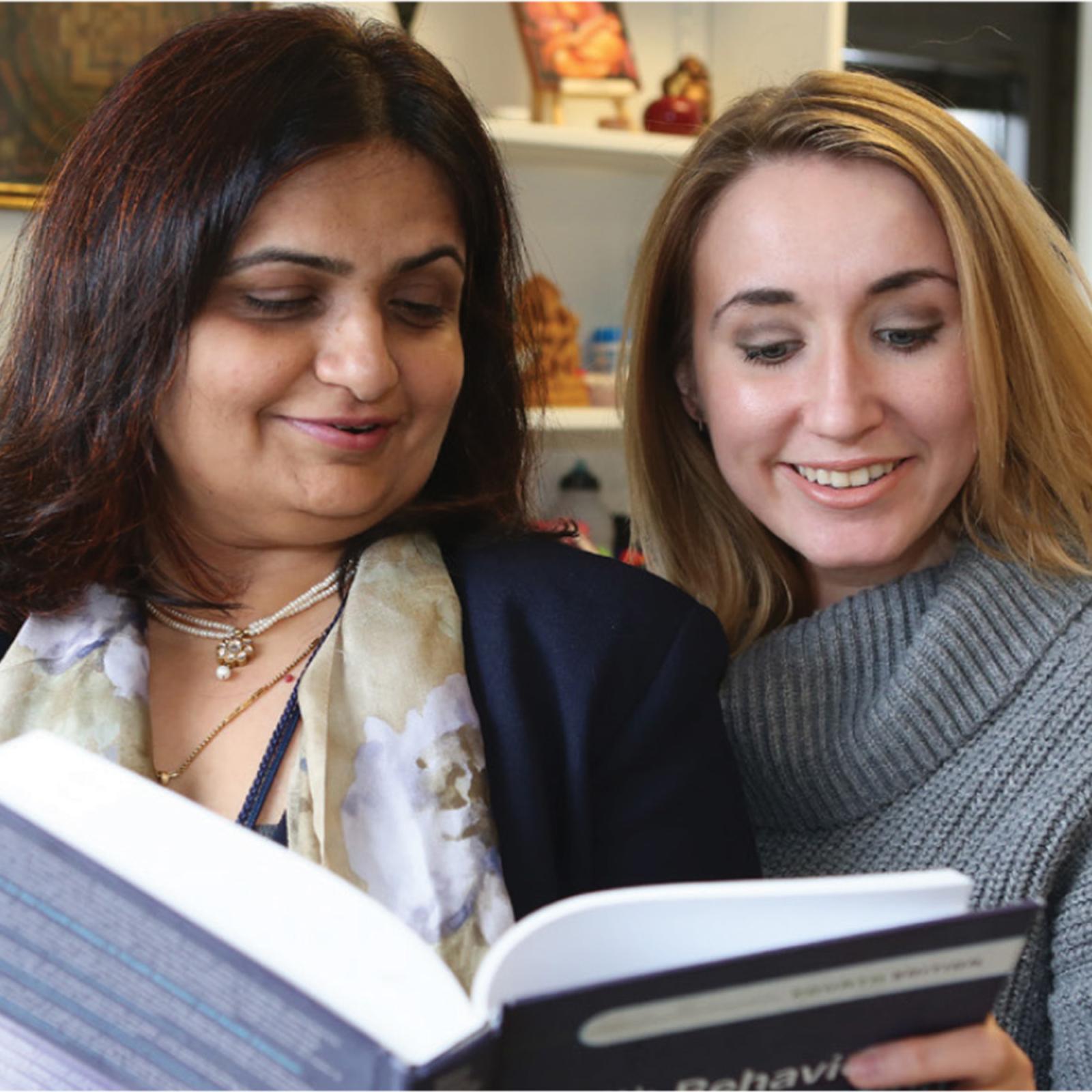 Pace University's Psychology NYC professor Sonia Suchday and student reading over Psychology textbook