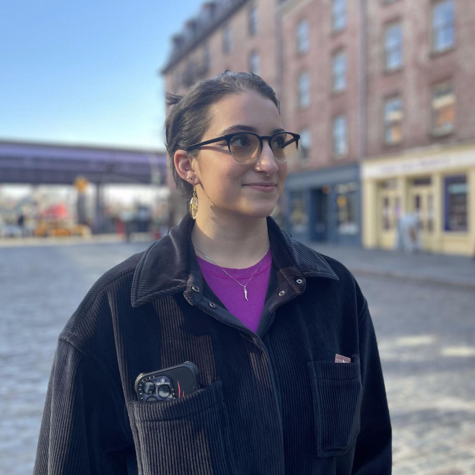 Pace Student Lauren DeMaio standing in front of old buildings in Seaport, NYC.