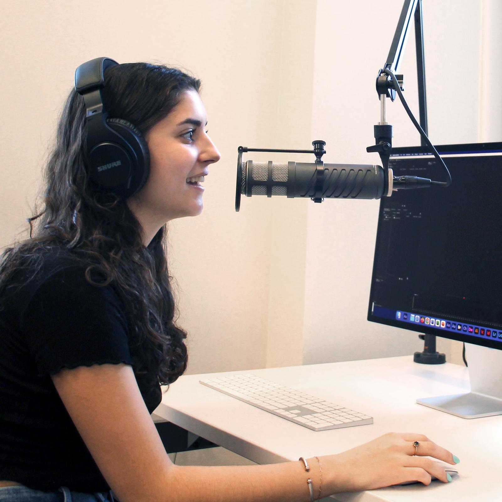Pace University Communication and Media Studies female student at computer with a microphone recording audio