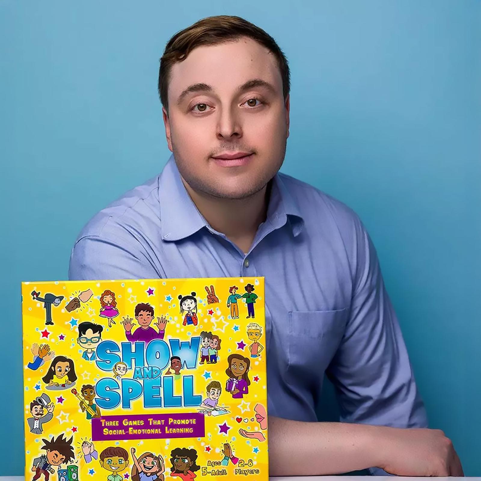 Stan Royzman, PsyD, a 2016 graduate of Dyson’s School-Clinical PsyD program posing with his children's board game called Show and Spell