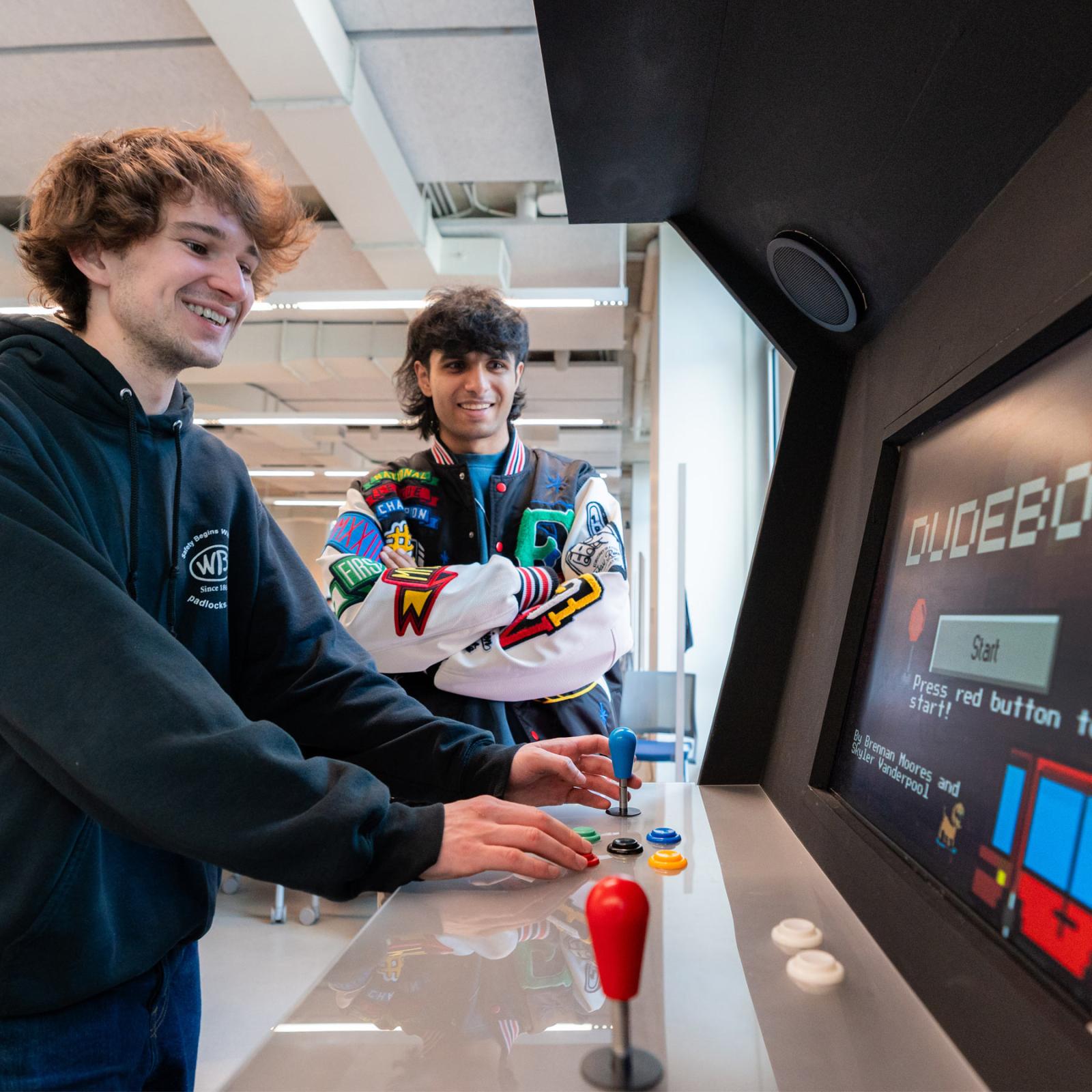 Pace students playing on a homemade arcade machine. 