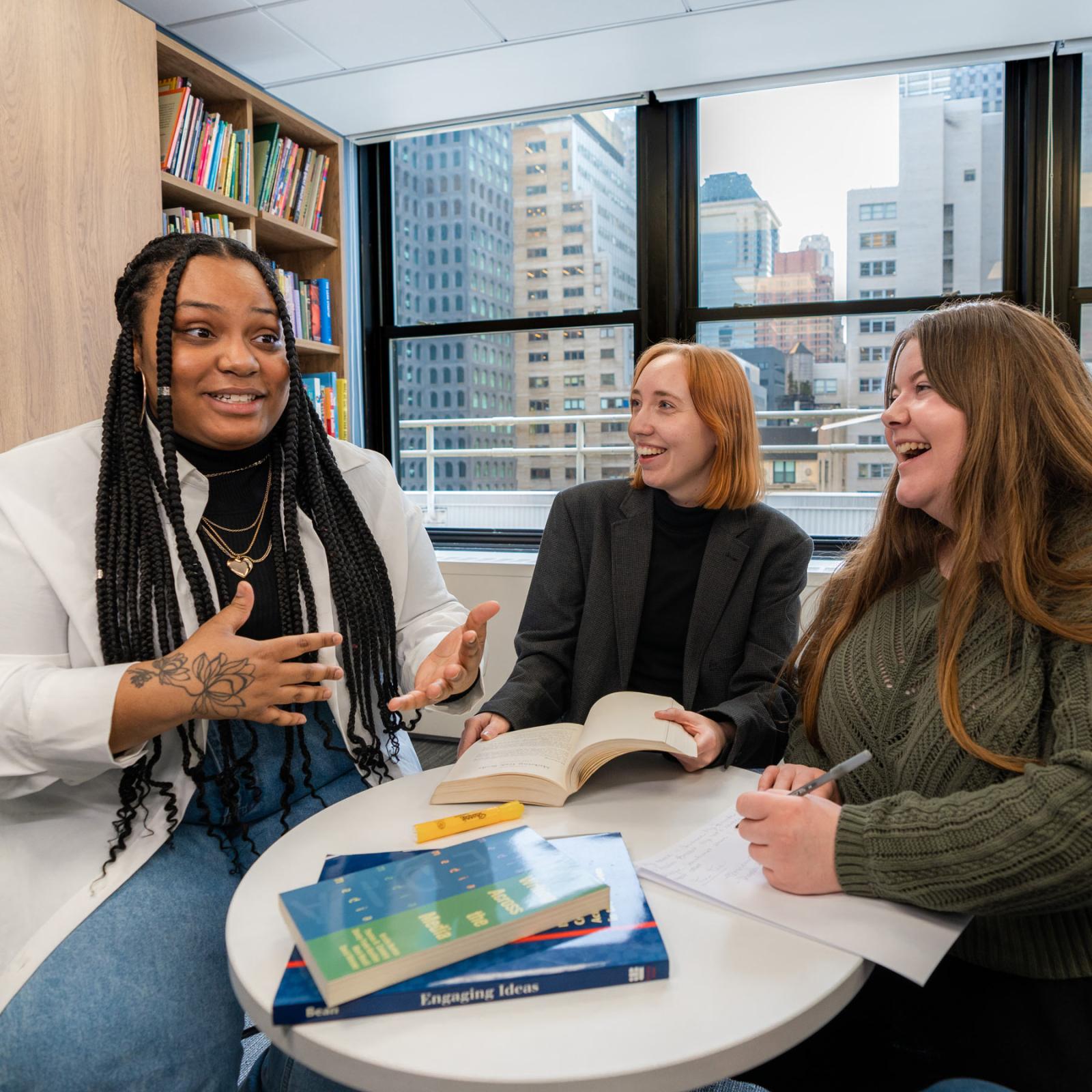 Pace student having an animated discussion at a table. 