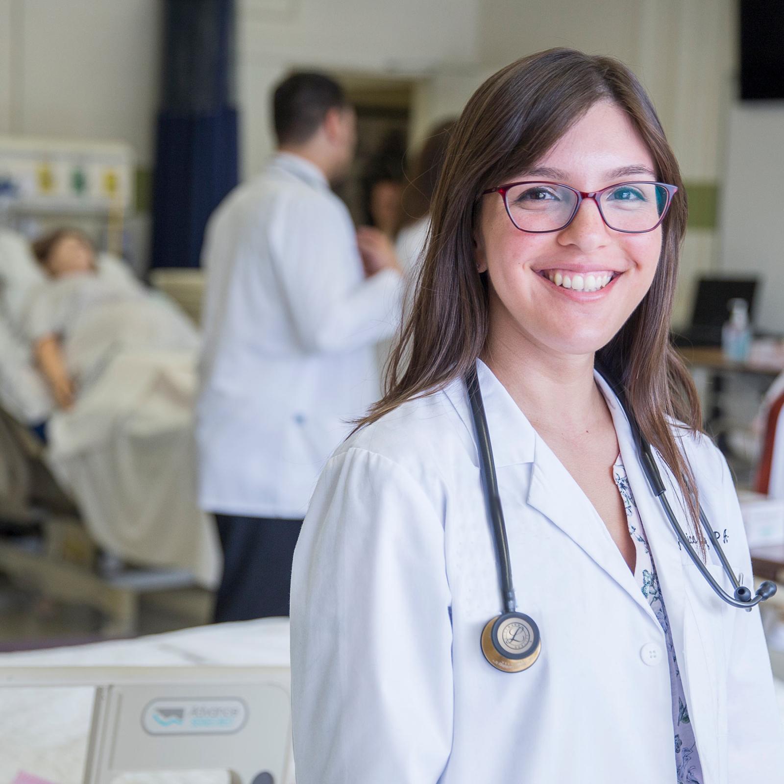 Pace University College of Health Professions student with a stethescope in a hospital setting 