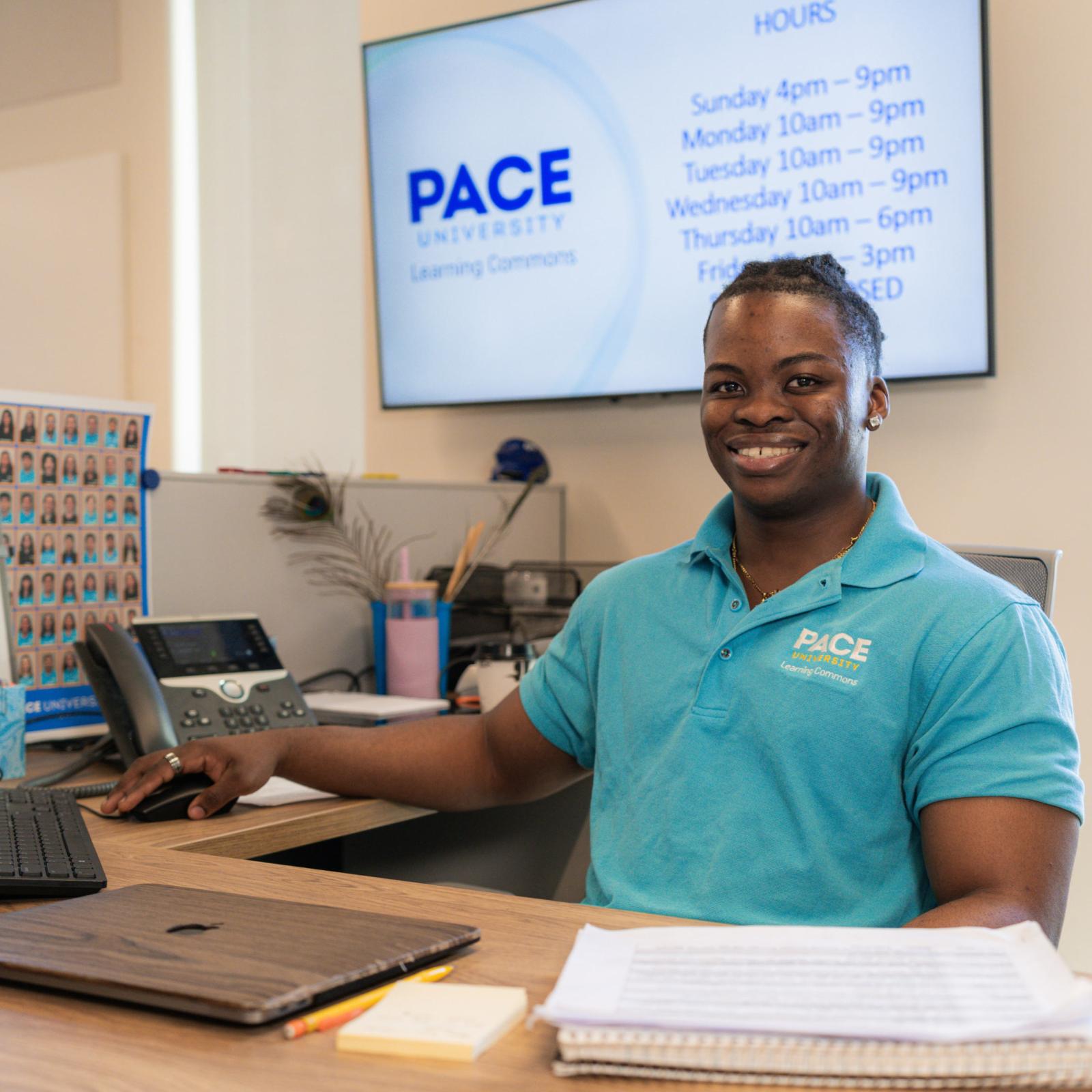 Pace University student working at the front desk of the Learning Commons