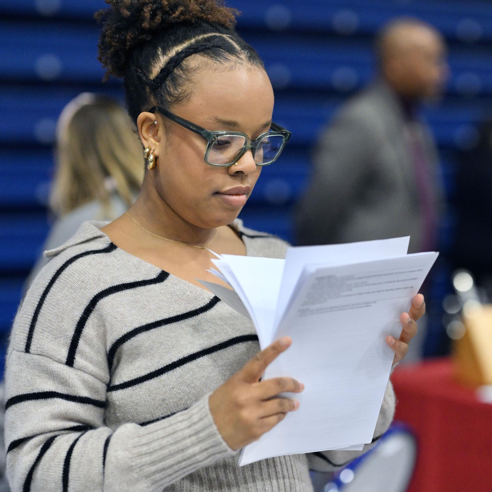 Pace University student looking at resumes at the Career Fair