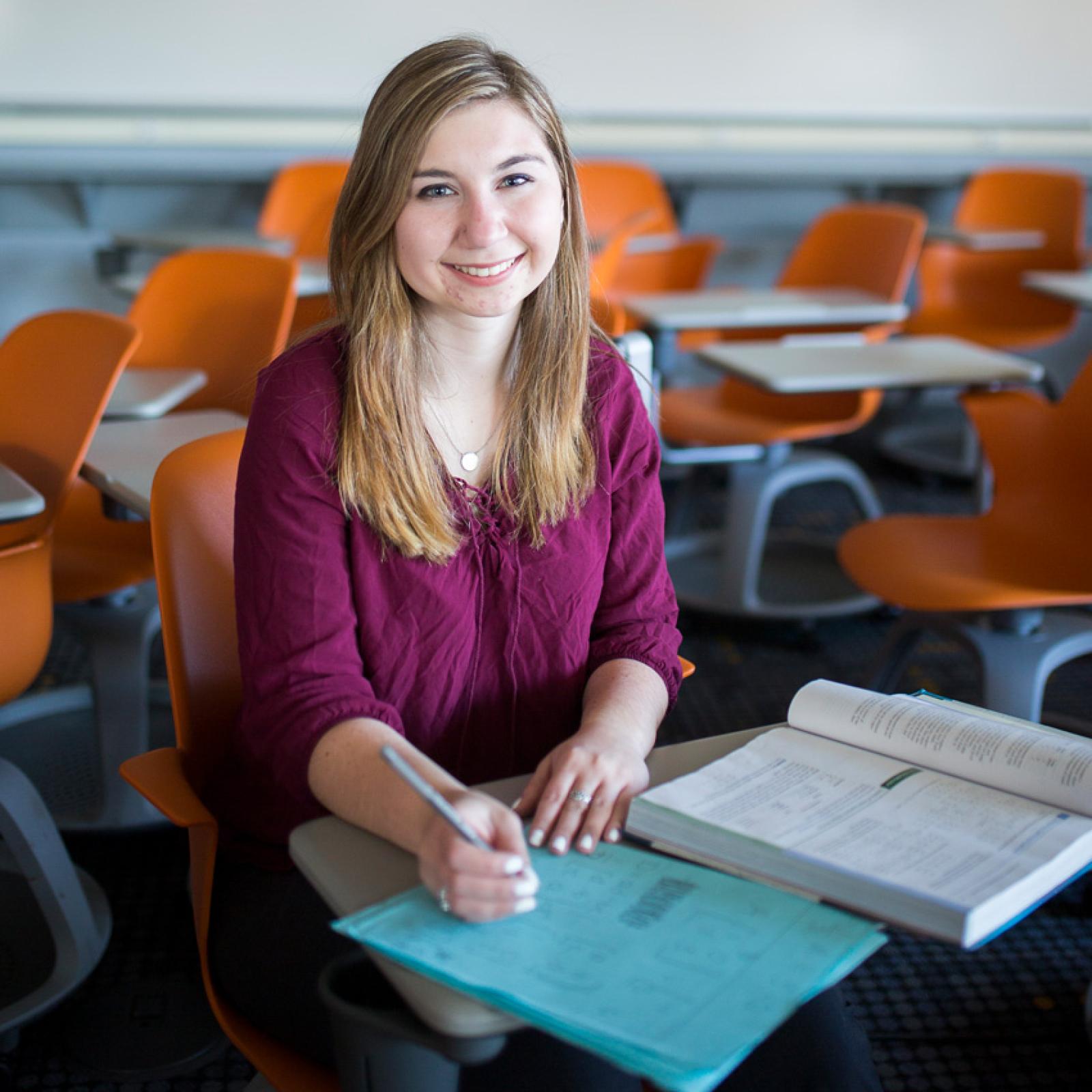 A woman sitting in a classsroom at Pace University.