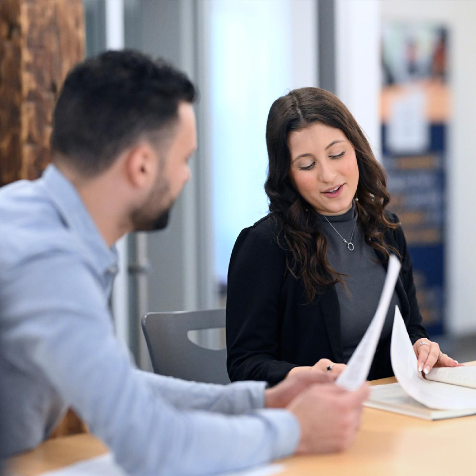 A man and a woman reviewing documents in an office. 