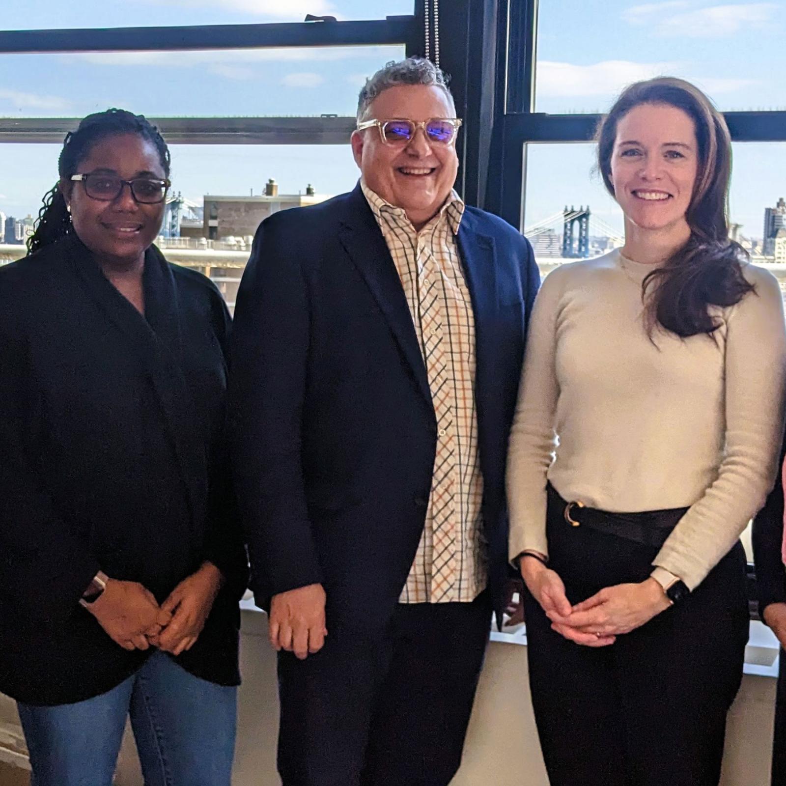 Pace University Public Administration faculty members standing in front of a window